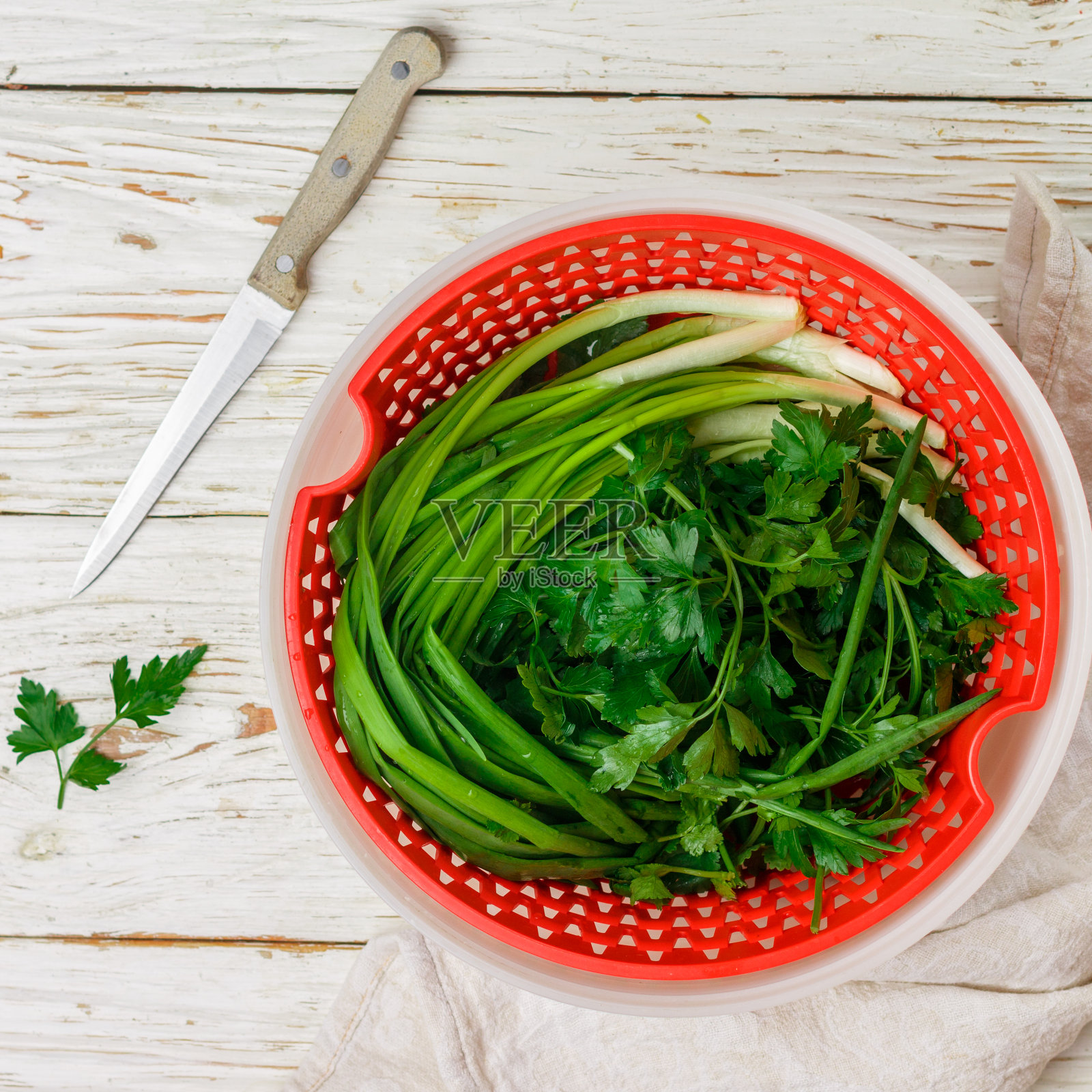 新鲜的有机蔬菜——绿色的洋葱，欧芹和香菜放在白色的木桌上。馅饼馅料。选择性对焦，方形图片照片摄影图片