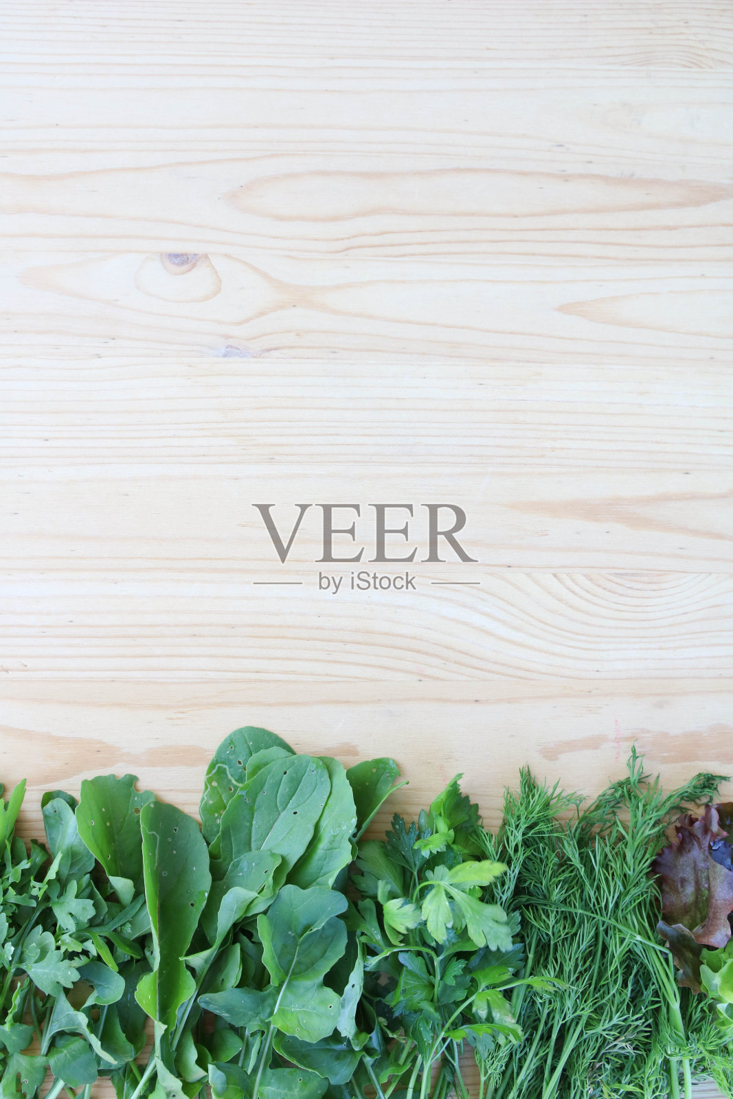 春天的混合。新鲜蔬菜沙拉。绿色沙拉框在木制背景与复制空间。垂直照片摄影图片