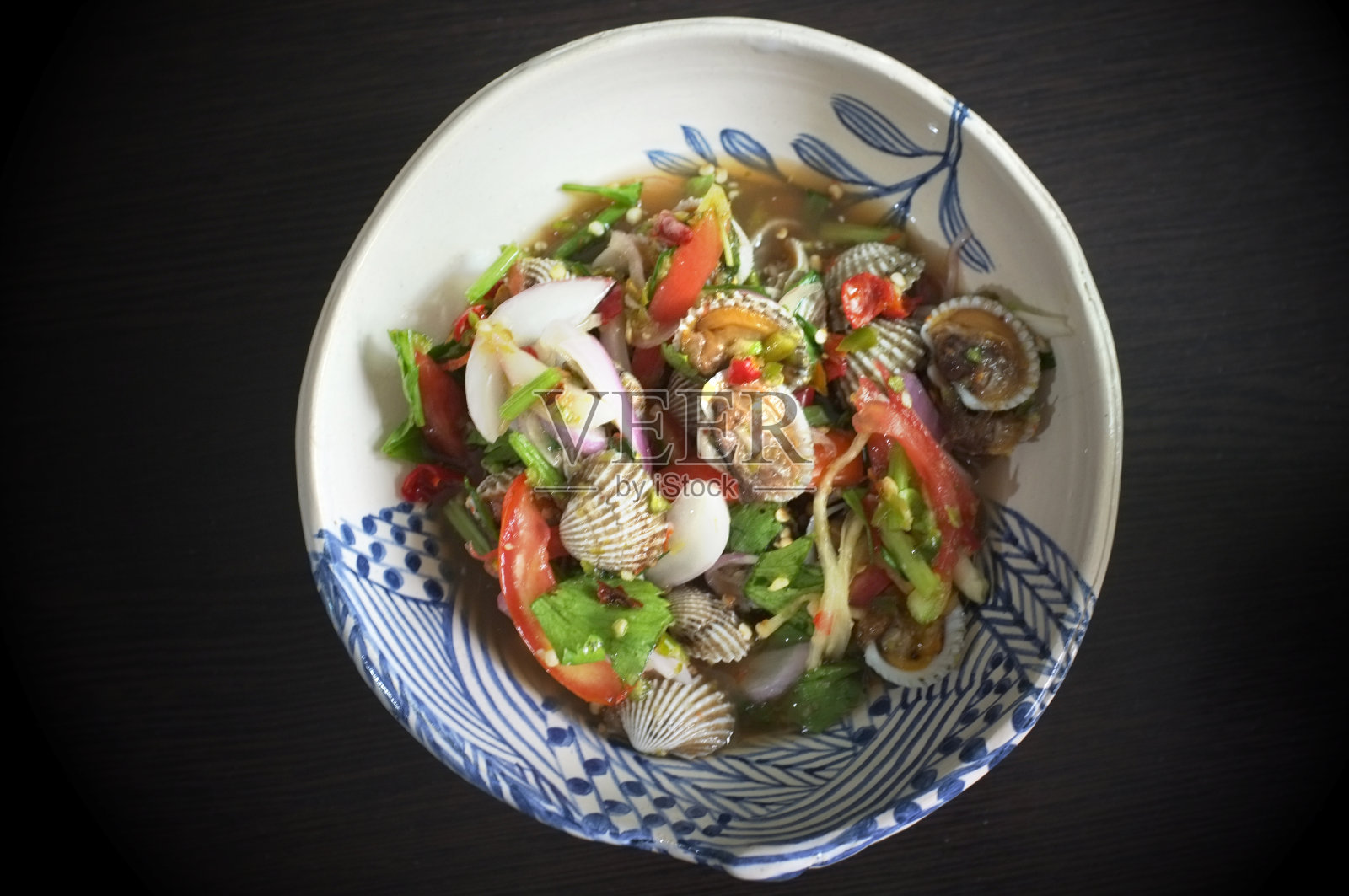 贝类沙拉/辣贝类血贝类沙拉混合蔬菜、番茄香草和香料，泰国风味照片摄影图片