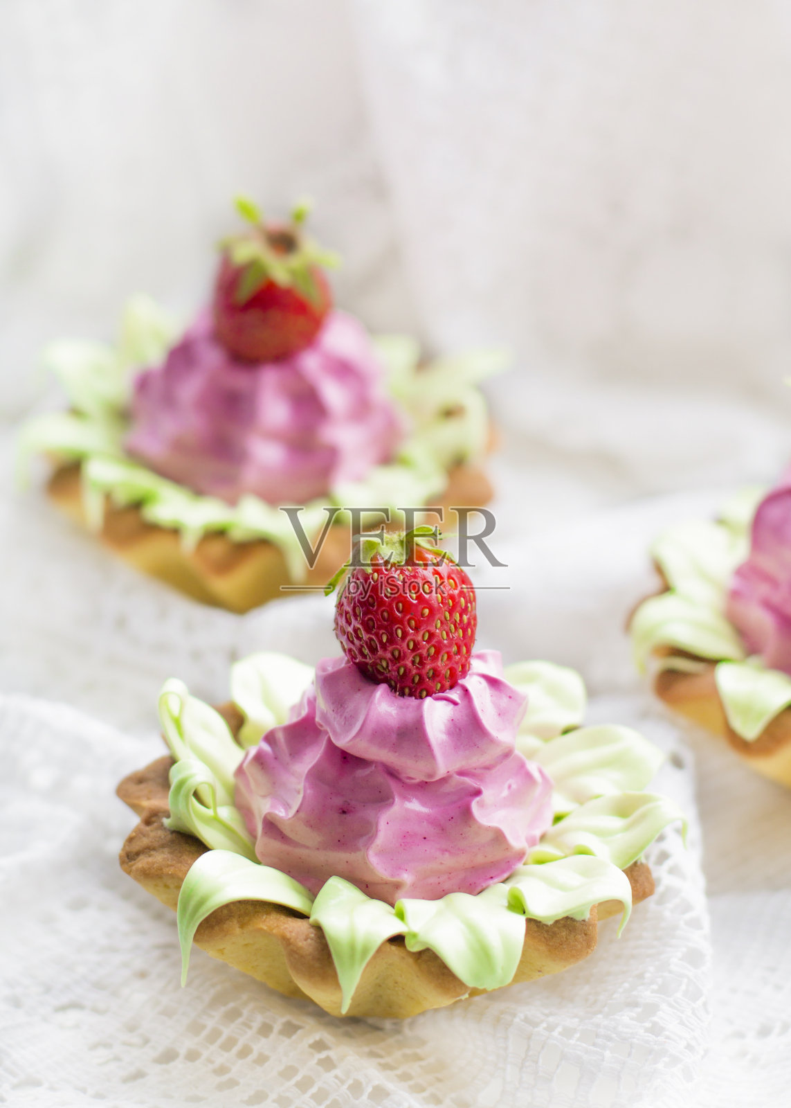 特写美丽美味的纸杯蛋糕与草莓，粉色和轻奶油照片摄影图片