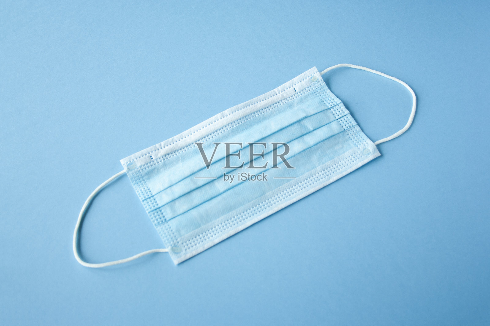 一次性医用口罩，蓝色背景，对抗细菌和病毒。阻止冠状病毒传播，自卫。本空间照片摄影图片