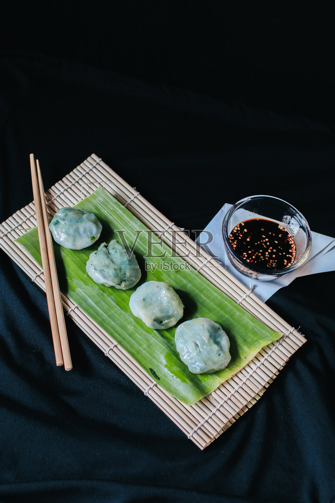 Kanom Gui Chai，以韭菜、芋头和竹笋为馅料的小点心/开胃菜，配以甜辣的蘸酱食用。传统的泰国街头美食。照片摄影图片