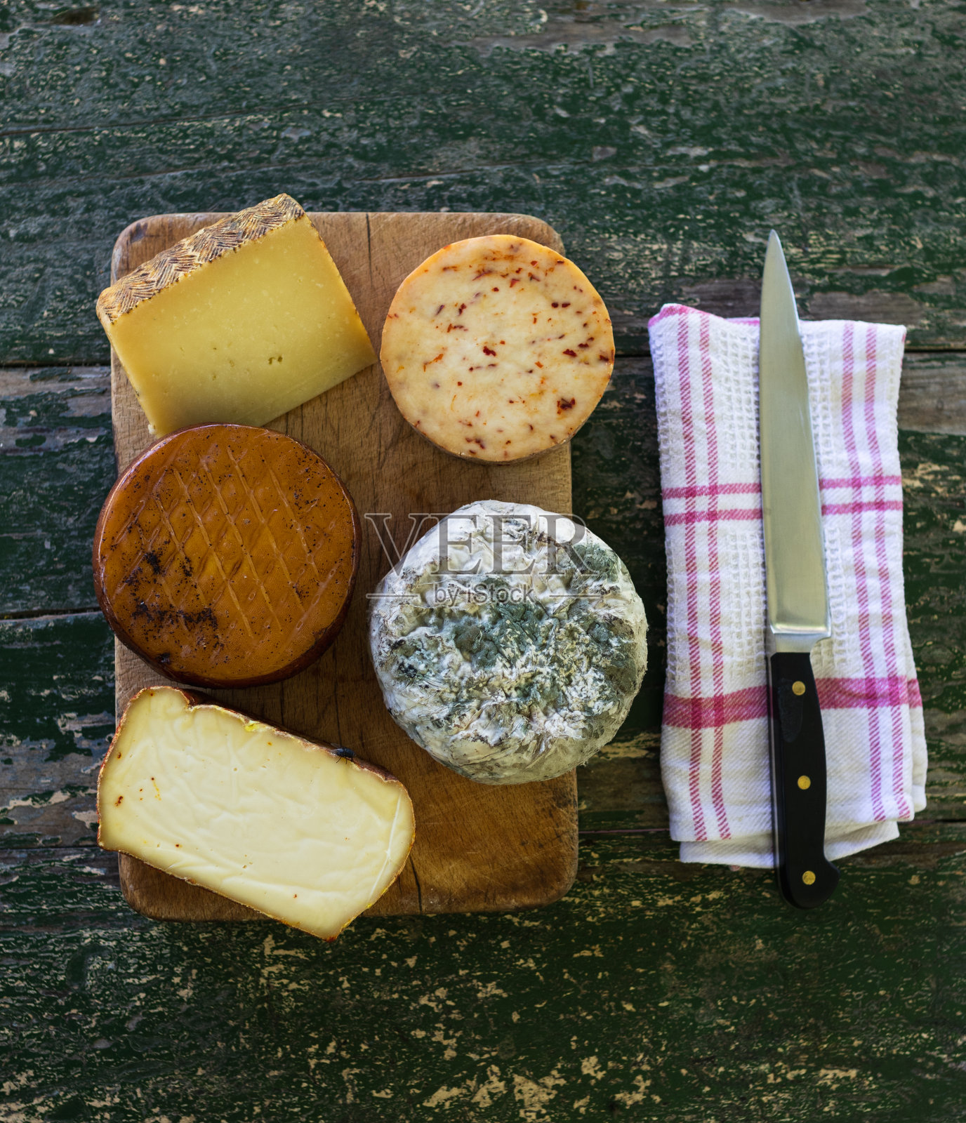 俯视图的桌子上的各种奶酪(蓝奶酪，烟熏奶酪…)在一个乡村的桌子上用刀照片摄影图片