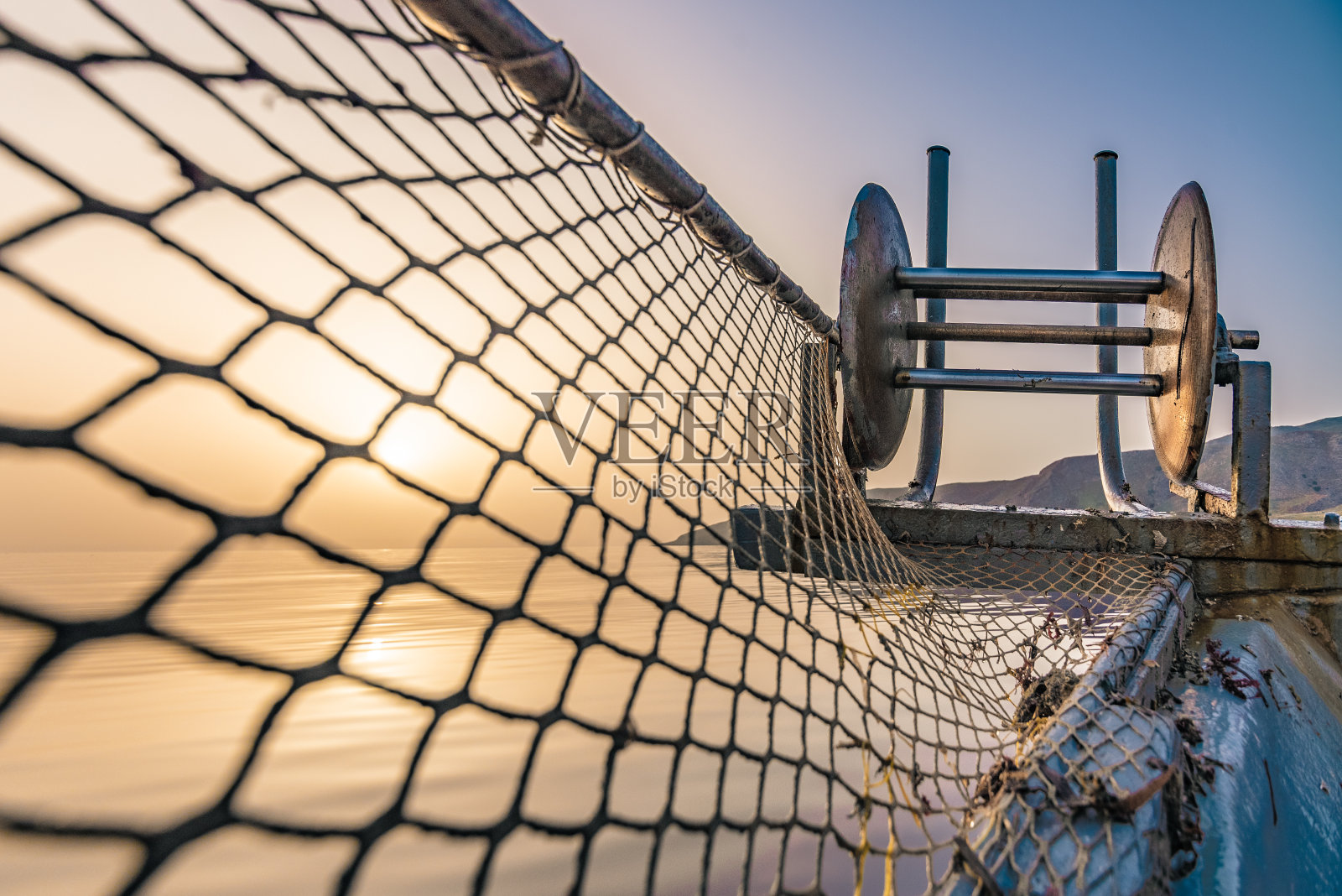 希腊克里特岛的渔船上，渔民正在用黄色的渔网捕捞新鲜的鱼。照片摄影图片