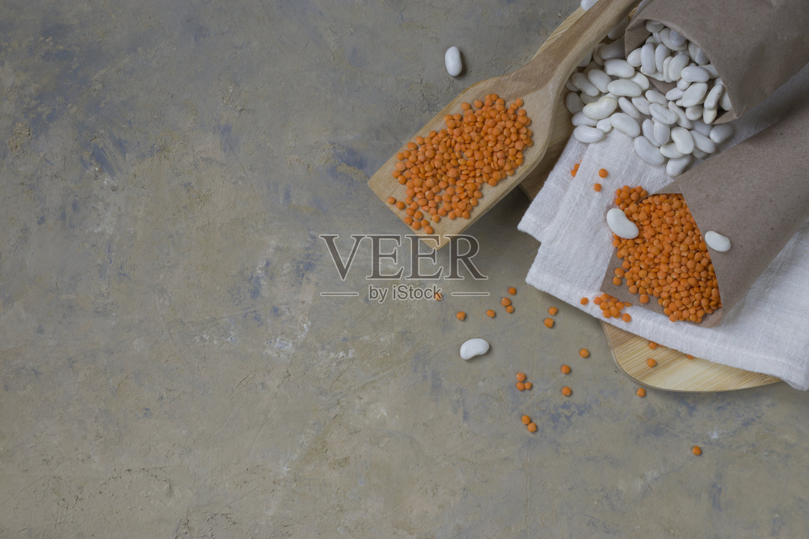 扁豆和白豆在牛皮纸包装在木板上。产品生态包装。素食主义者的健康食品。照片摄影图片