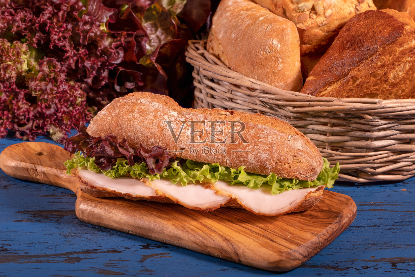 木背景上有意大利腊肠和沙拉的三明治照片摄影图片