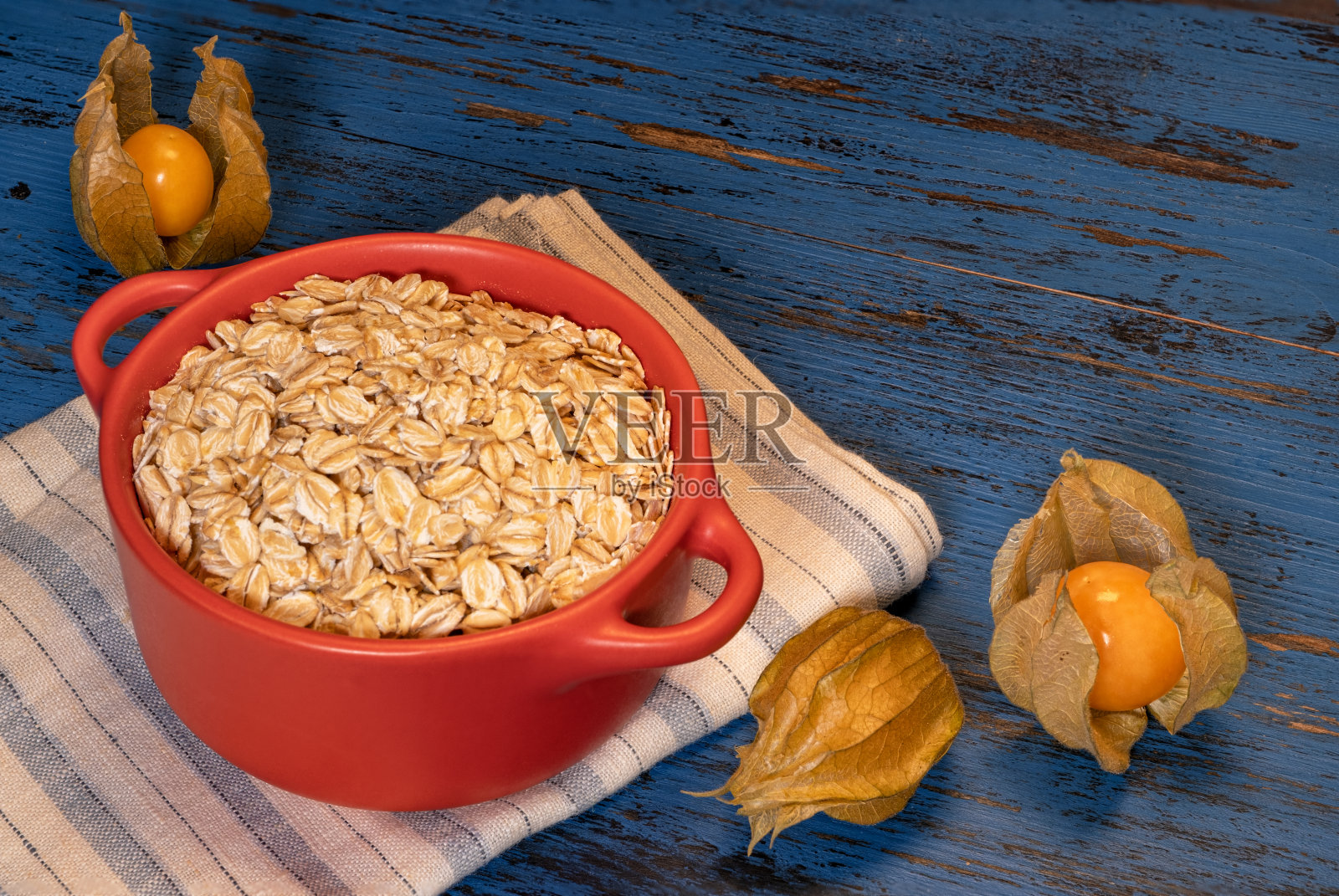蓝色木质背景的燕麦片和坚果照片摄影图片