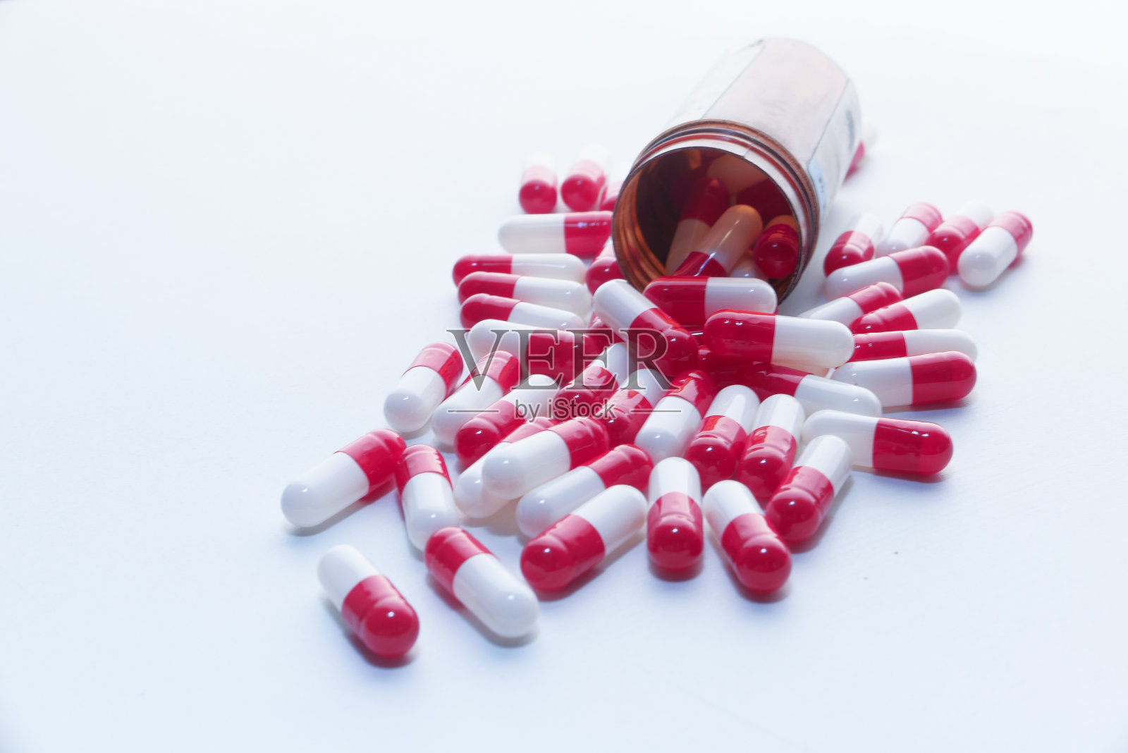 白色和红色的胶囊溢出与复制空间的白色背景照片摄影图片
