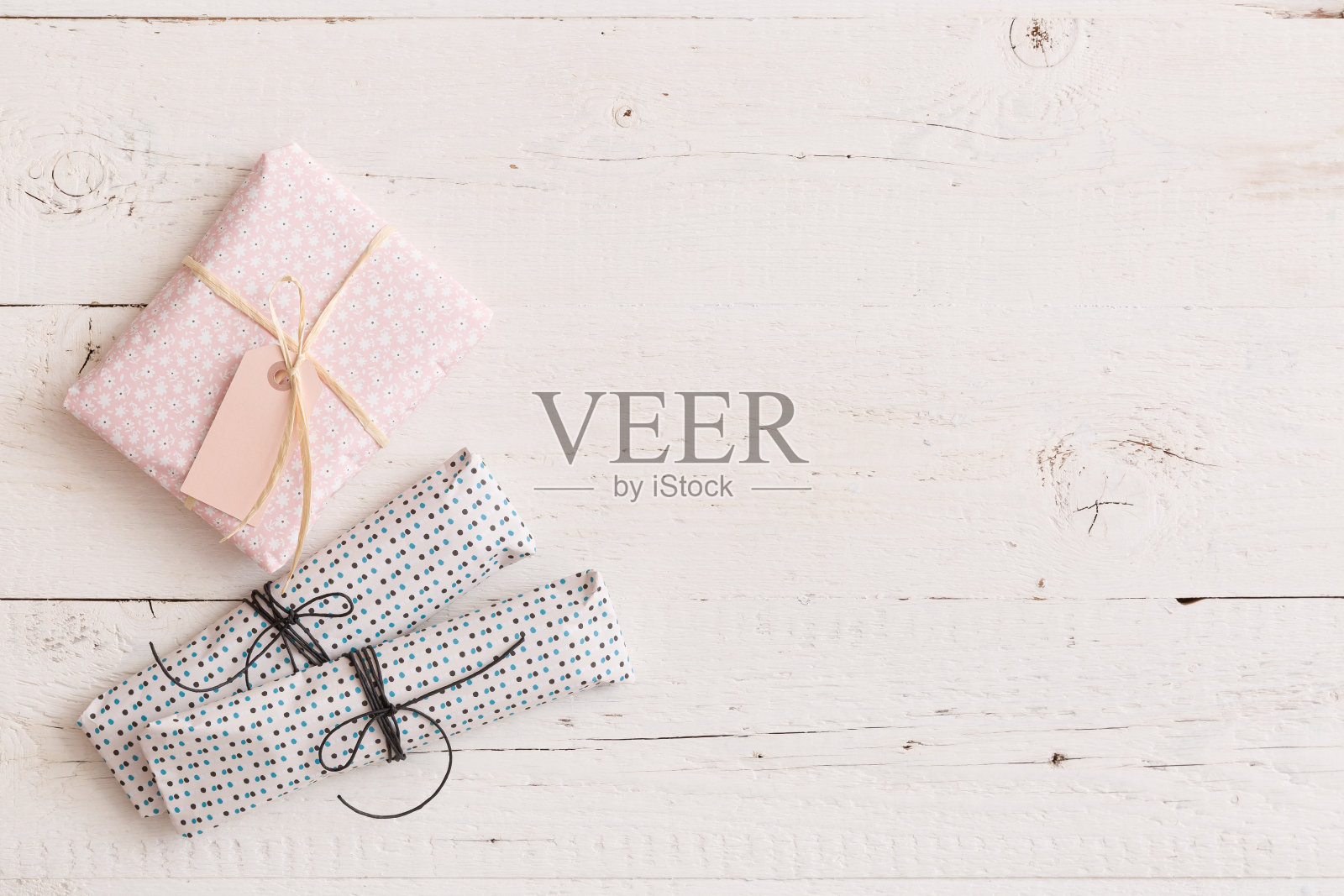 顶视图上的小包装礼物与丝带和标签上的白色木制背景。生日、圣诞节或其他庆祝活动的礼物。照片摄影图片