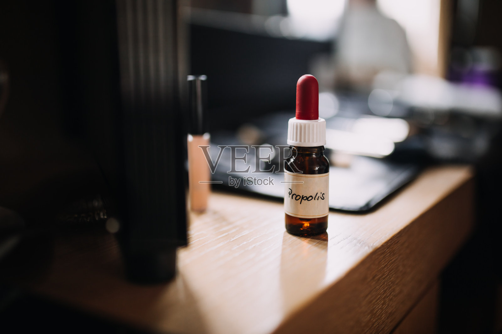 桌上一个蜂胶瓶的照片照片摄影图片