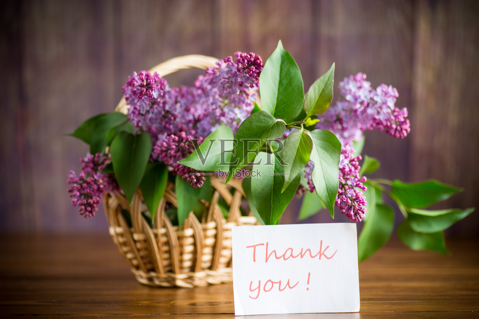 一束盛开的紫丁香放在篮子里照片摄影图片