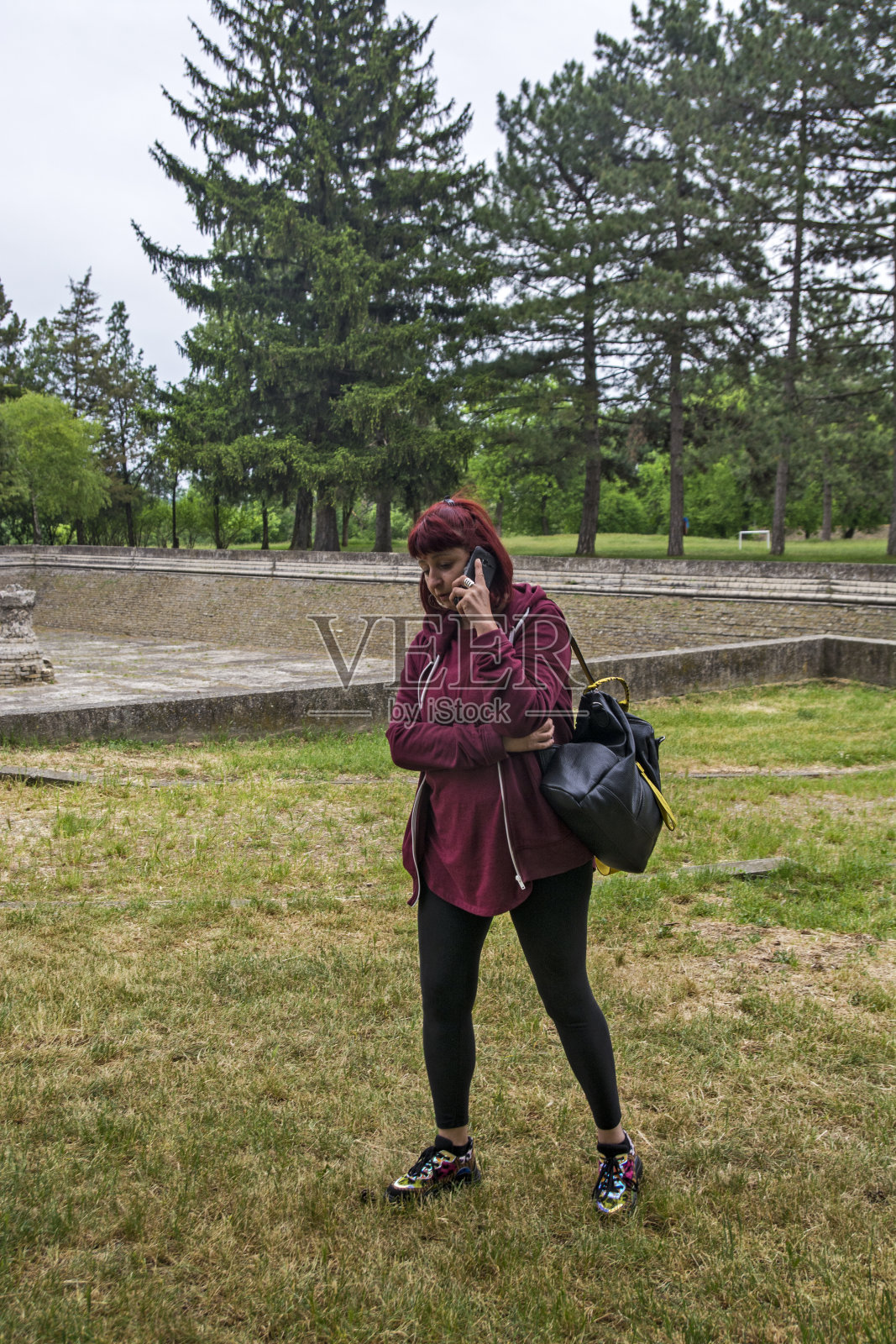 一个年轻女子在公园里打了一个电话照片摄影图片