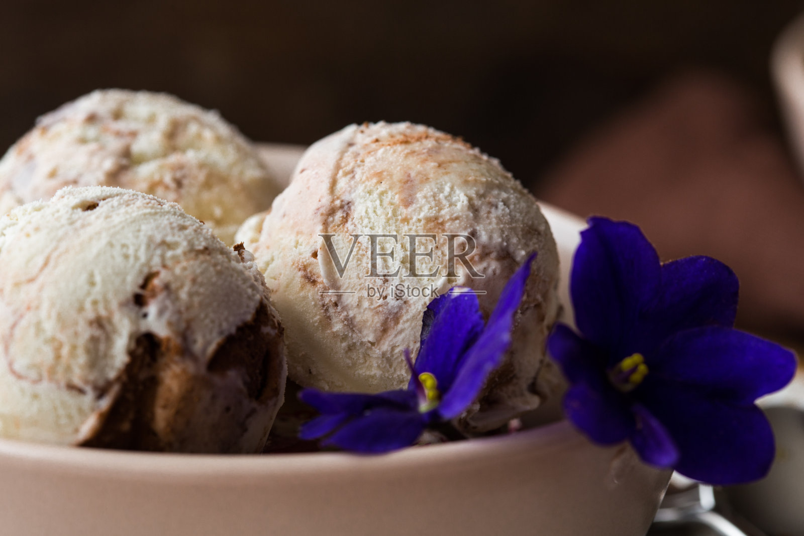 巧克力冰淇淋球和香料碗，花，巧克力装饰。夏日美食概念与复制空间。照片摄影图片