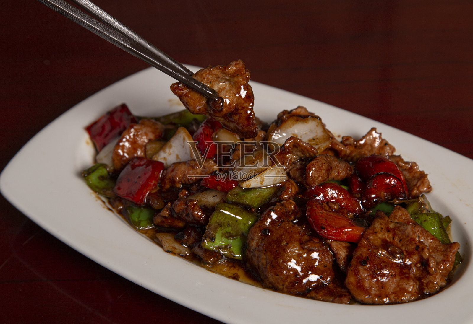 豆瓣酱青椒小牛肉。中国的筷子。孤立的形象照片摄影图片