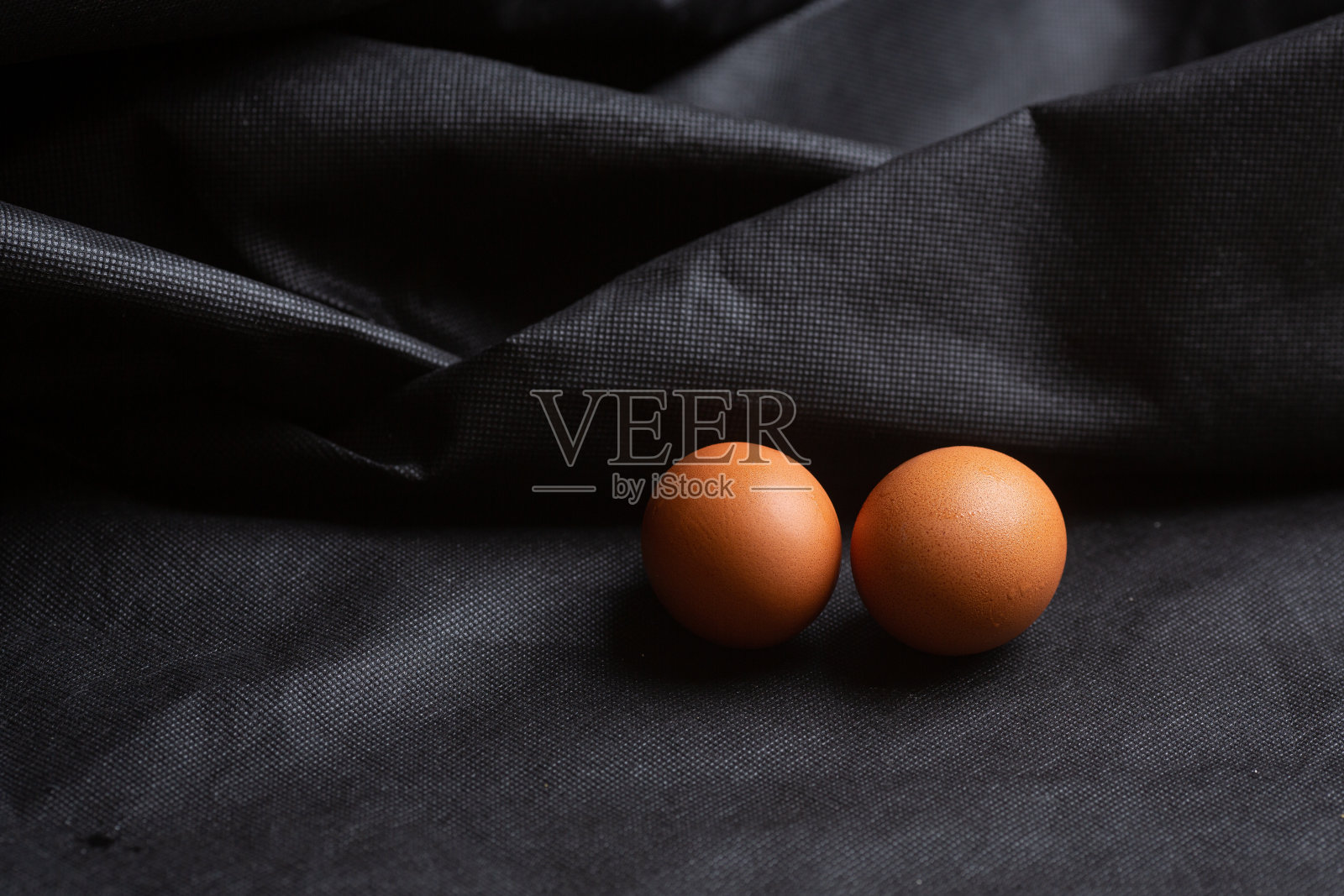 鸡蛋在黑色的织物背景照片摄影图片