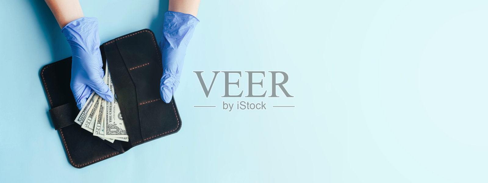 双手戴着手套数美元货币。照片摄影图片