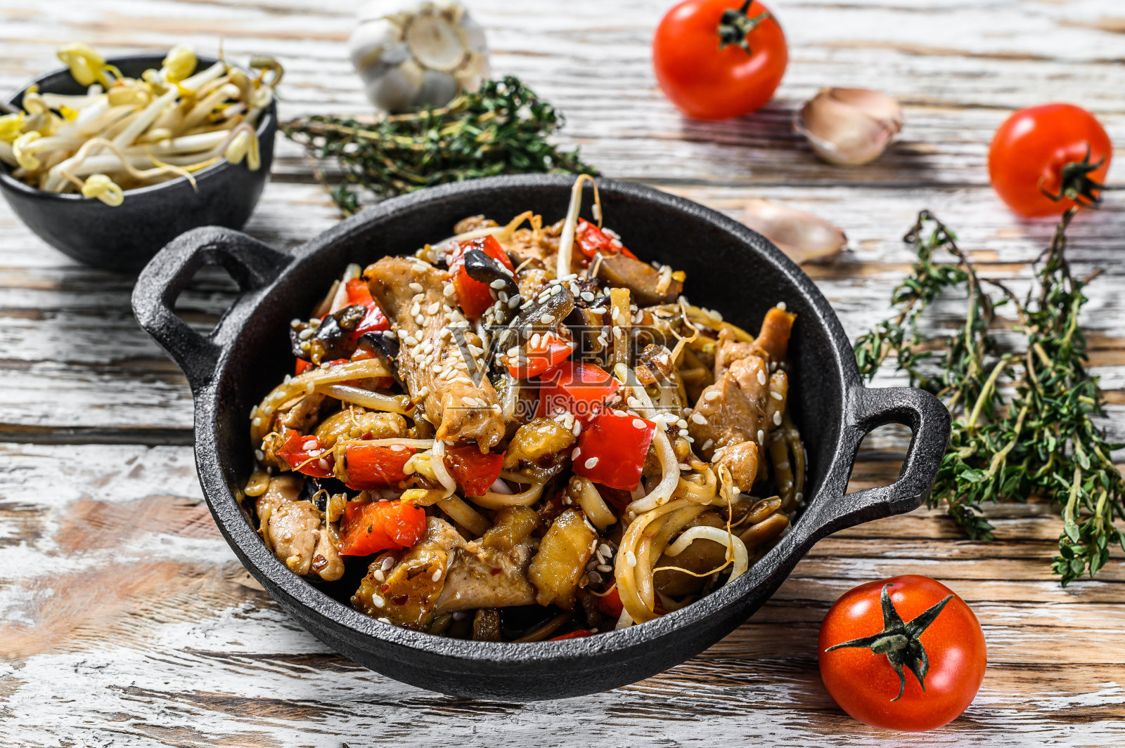 乌冬面与鸡肉和蔬菜在平底锅中煸炒。白色背景。俯视图照片摄影图片