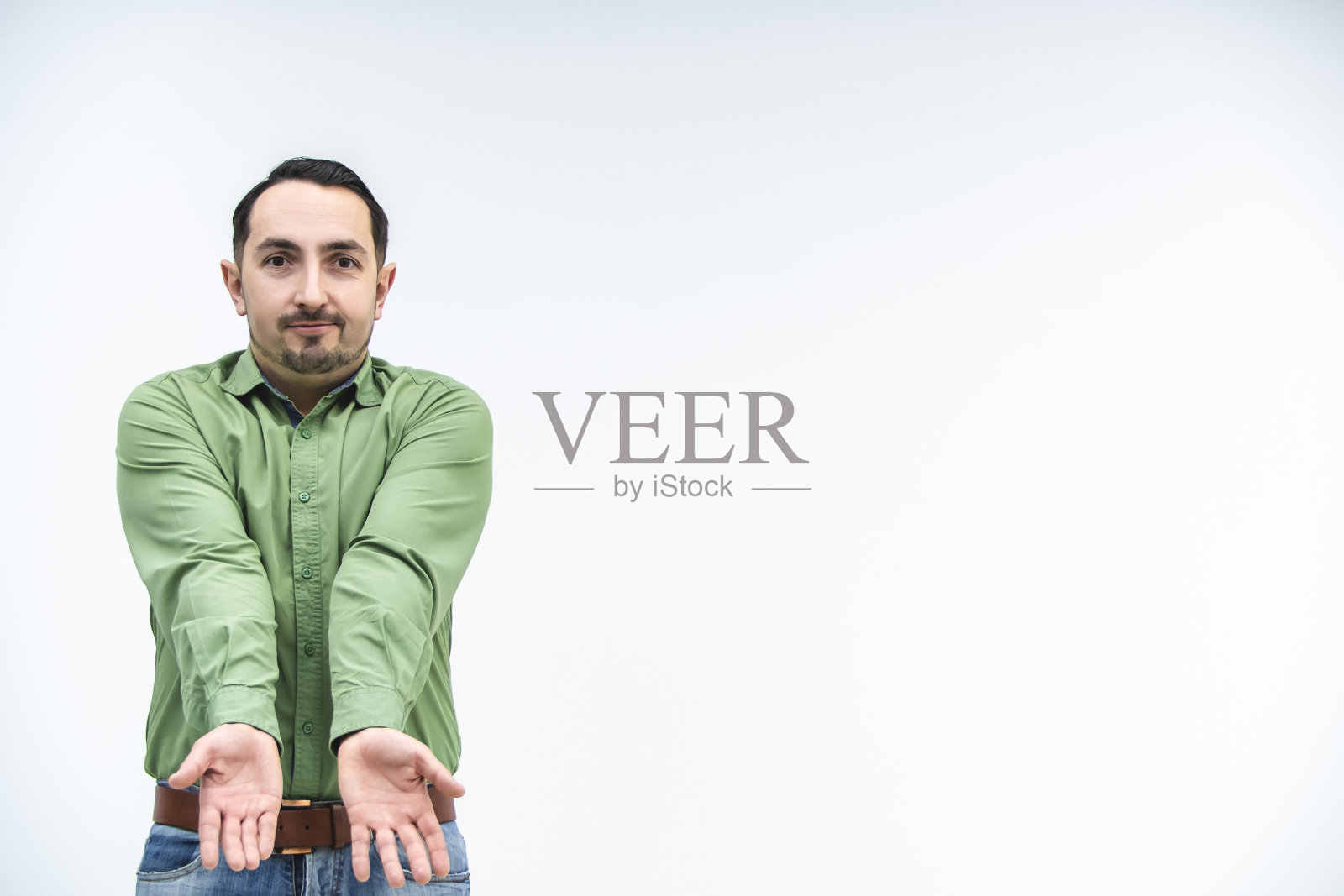 有吸引力的年轻人的手势表明他是诚实的脸上愚蠢的表情。照片摄影图片