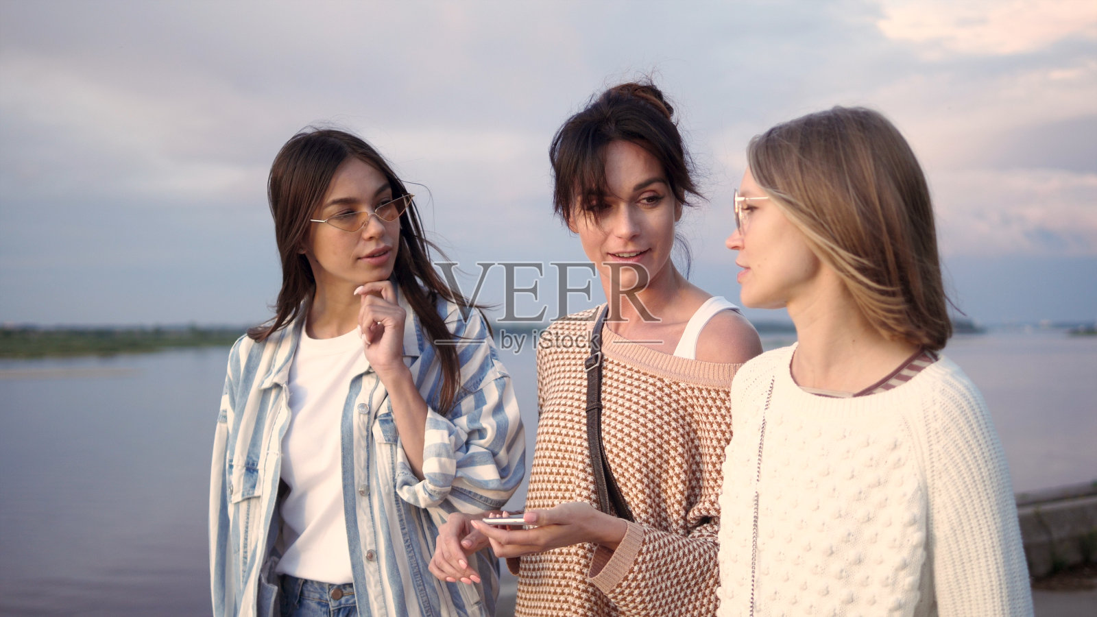 开心的女性朋友在智能手机上进行语音搜索照片摄影图片