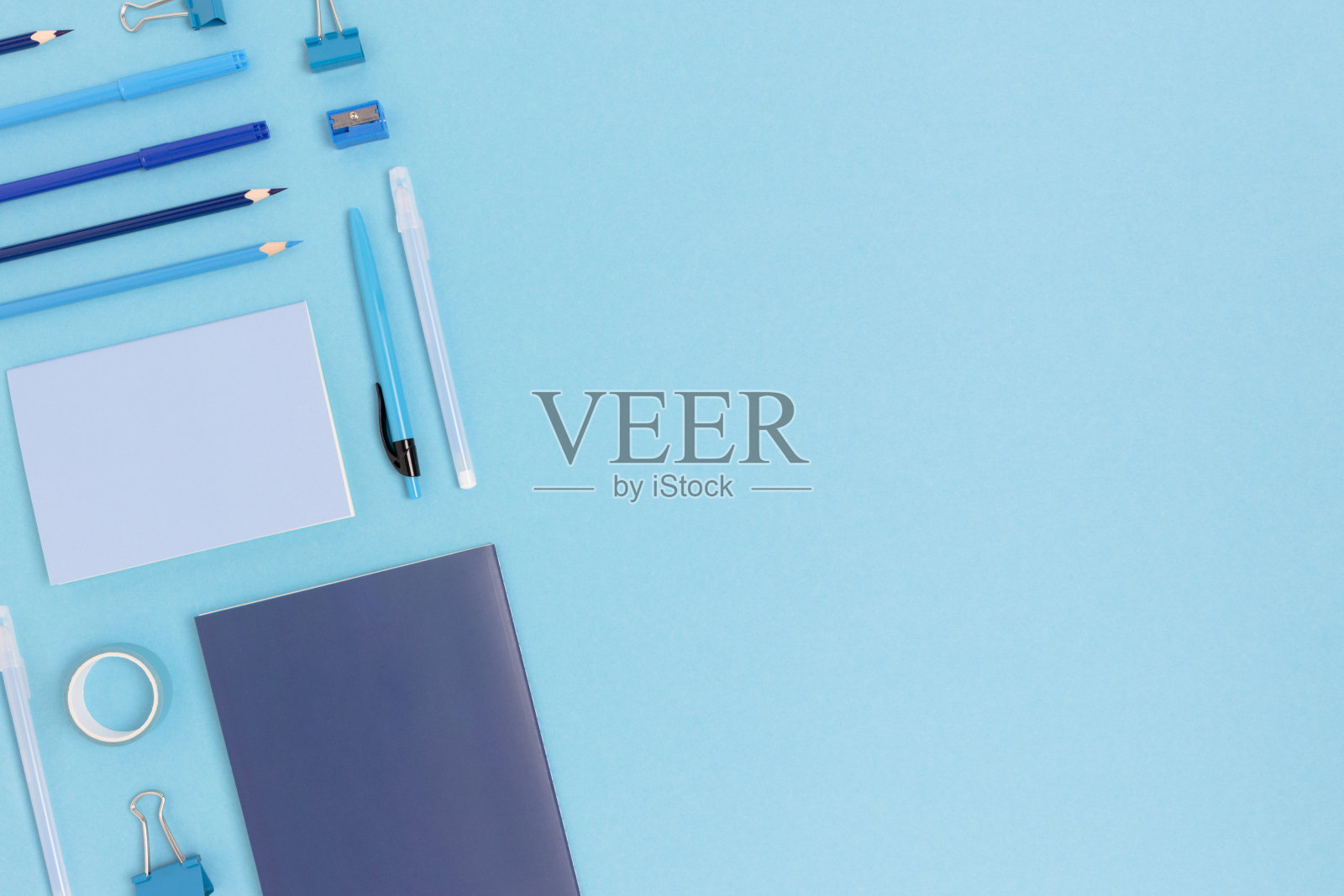 在蓝色粉彩背景上布置办公用品。照片摄影图片