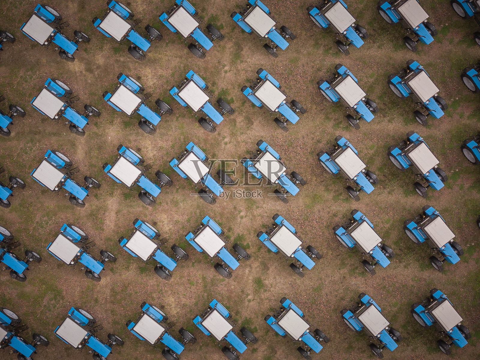 农田里的蓝色拖拉机。空中从上向下拍摄。照片摄影图片