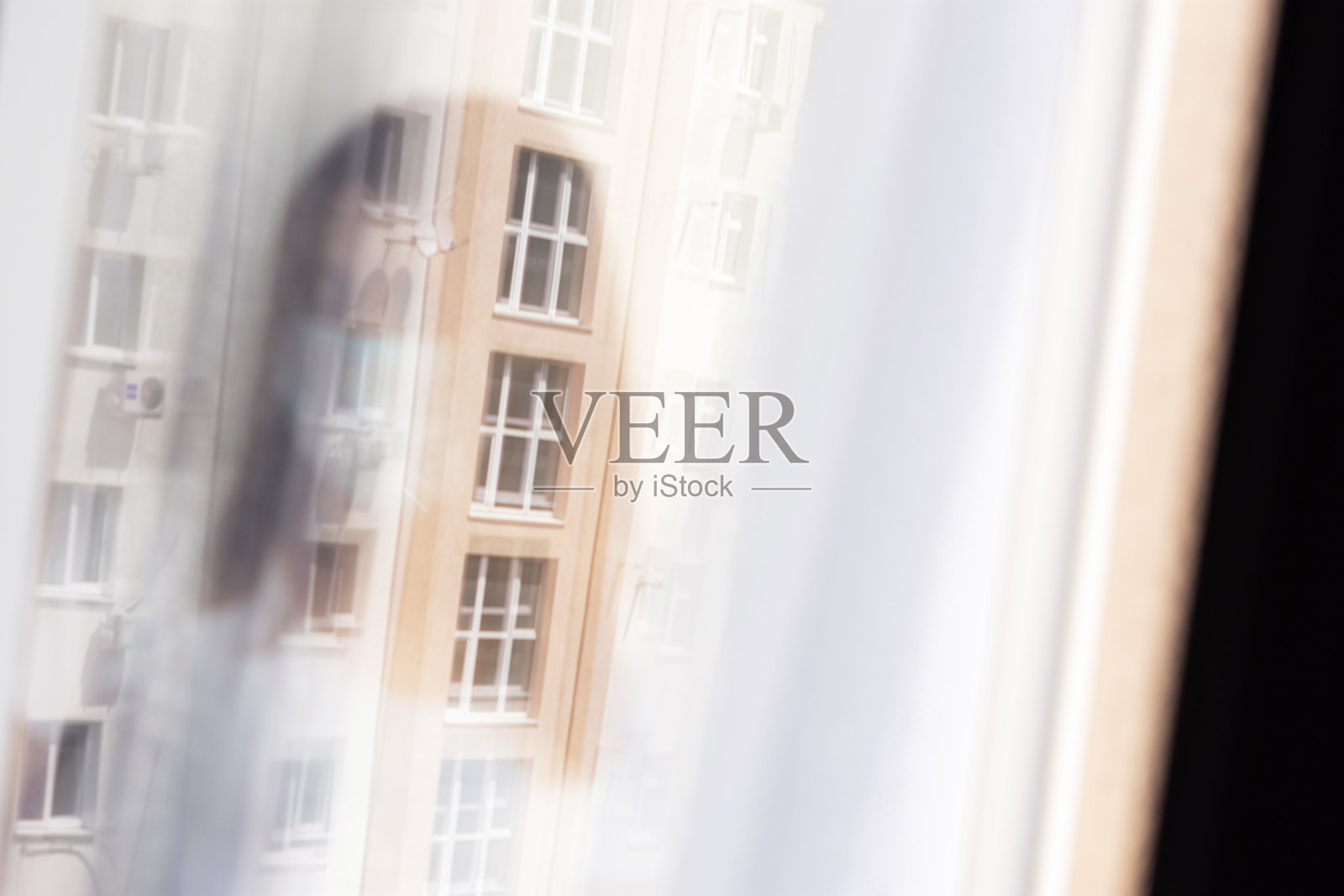 戴防护面罩、站在玻璃后的女孩肖像照片摄影图片