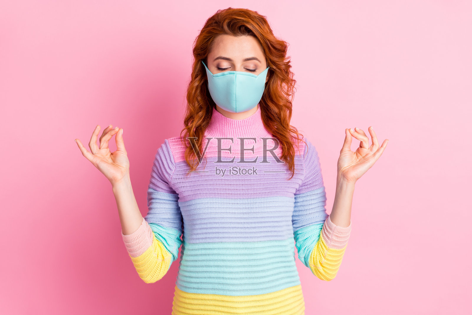 相当放松的女士的照片保持社交距离练习瑜伽眼睛闭上手指在一起控制身体和思想穿保护面罩毛衣孤立的粉色背景照片摄影图片