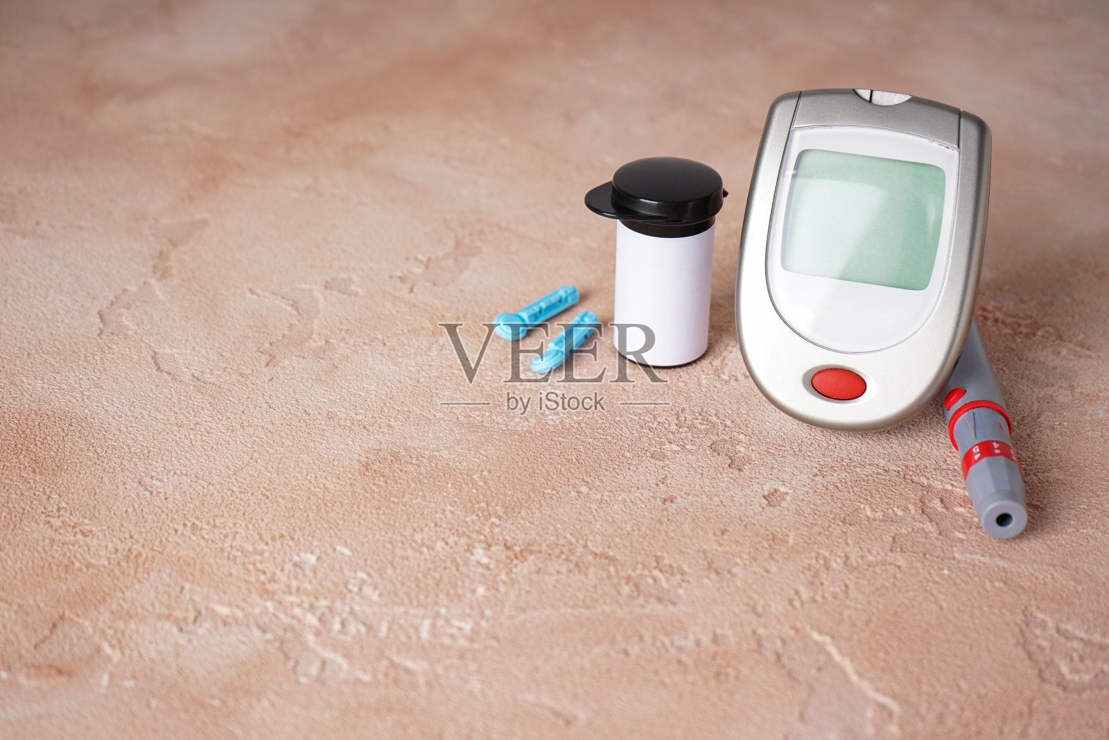 数字血糖仪，柳叶刀钢笔米色背景与文字空间。糖尿病的概念。照片摄影图片