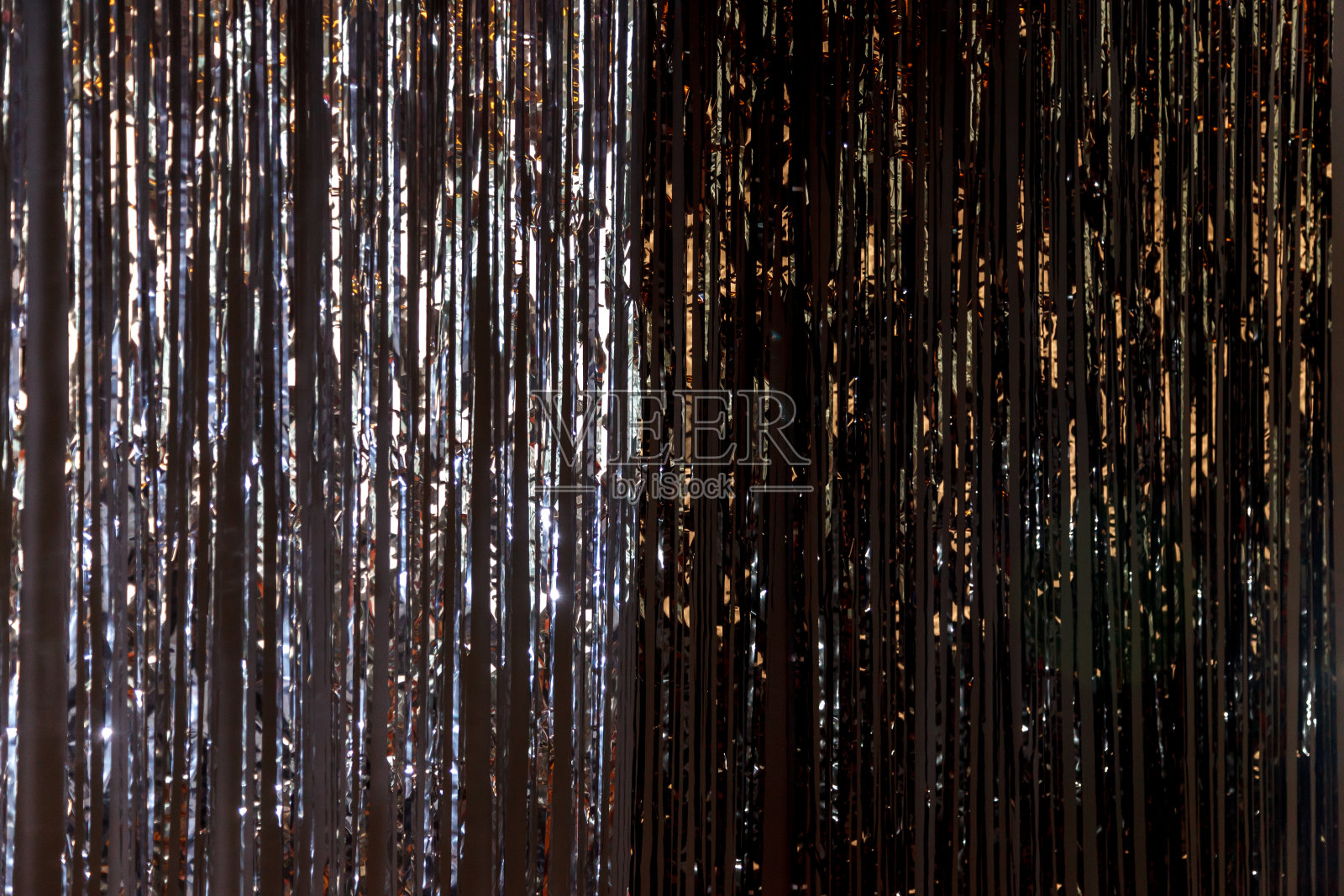 明亮的背景由金属箔制成，在黑暗的墙壁上照片摄影图片