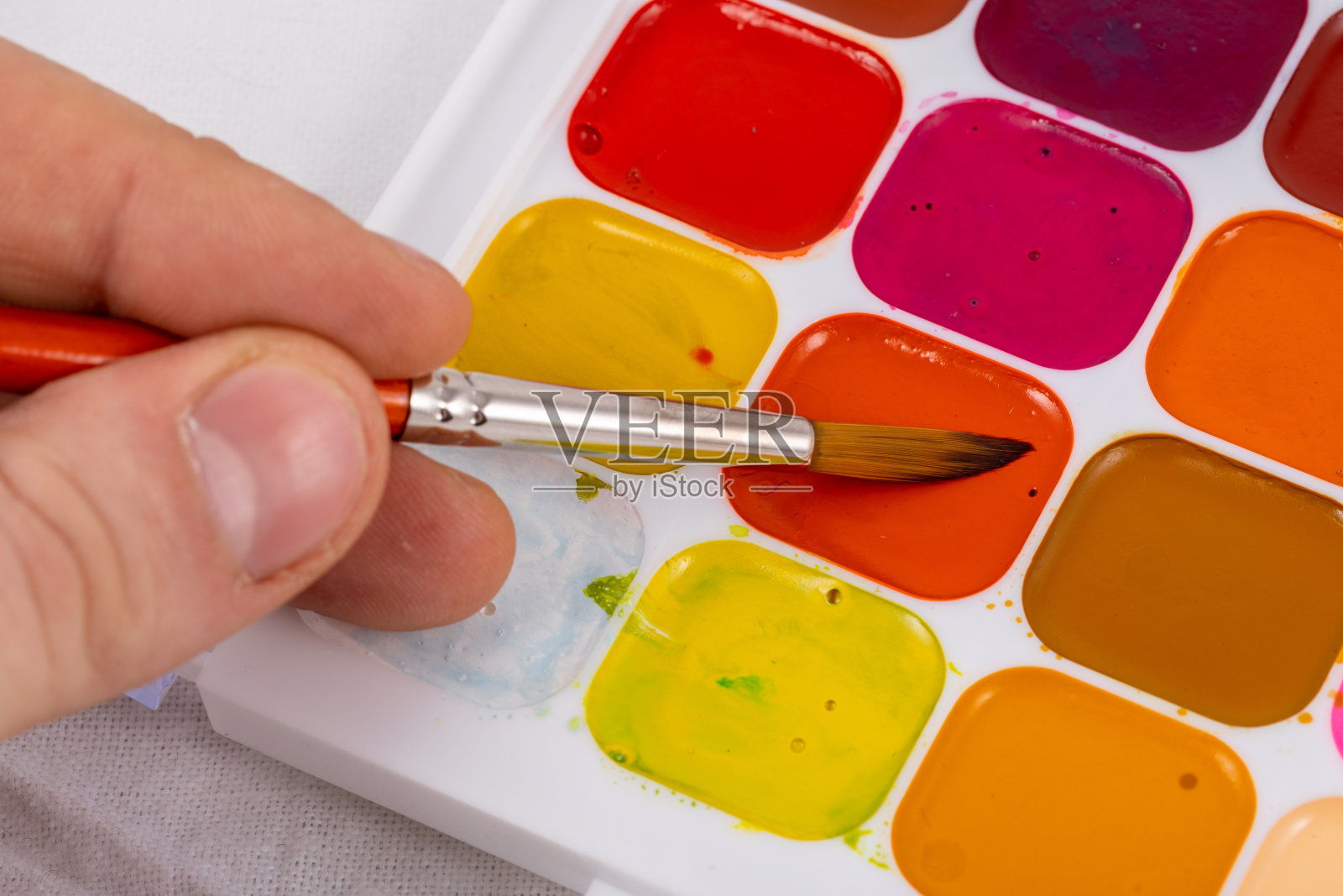 一套水彩颜料和合成画笔绘画。绘画的过程。照片摄影图片