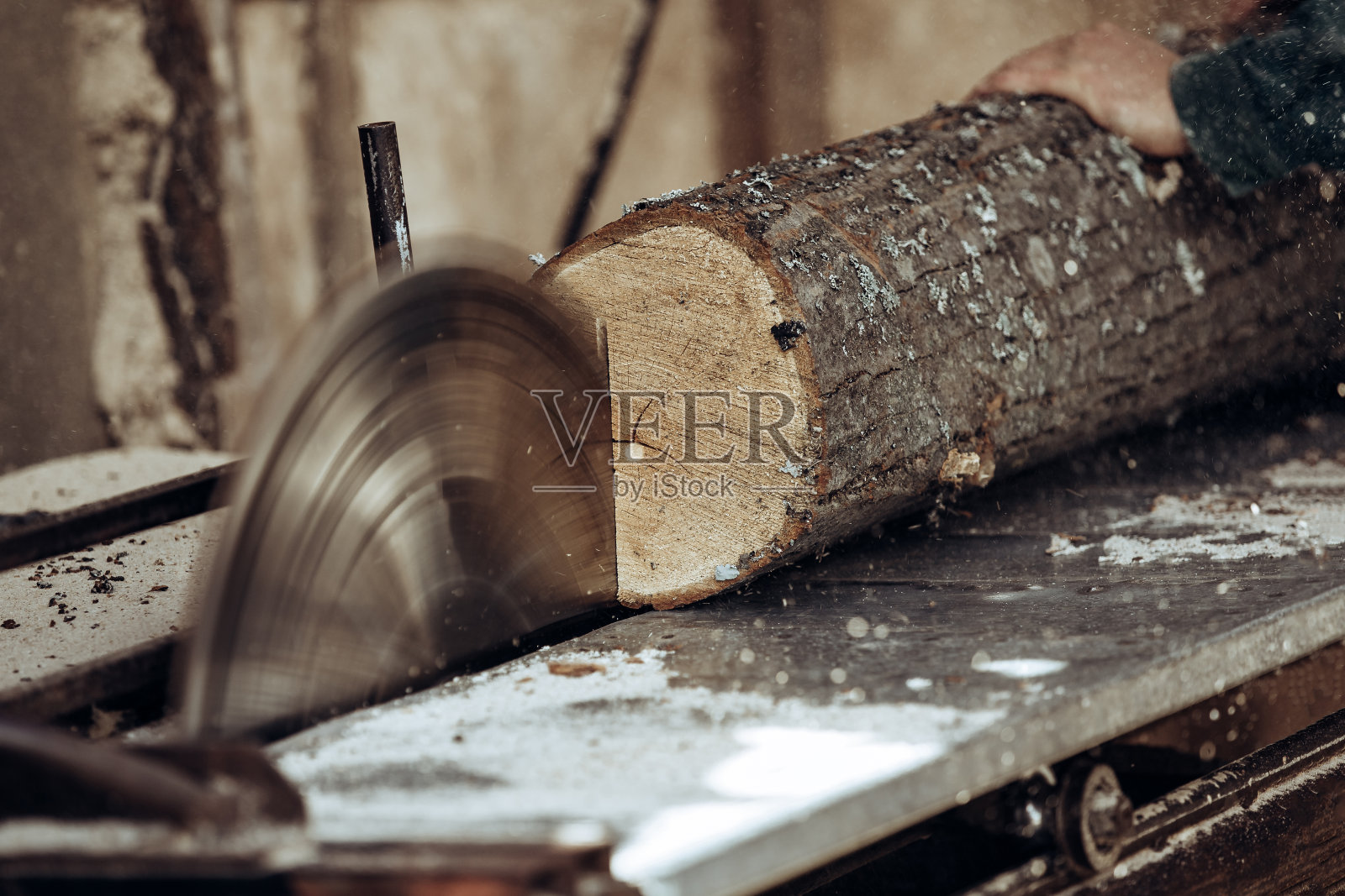 木匠用圆锯切割木板。照片摄影图片