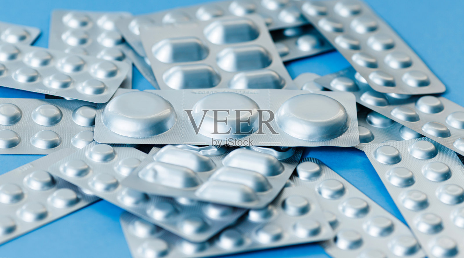 不同的药丸水泡。医疗保健的概念。淡蓝色纸背景与复制空间。照片摄影图片