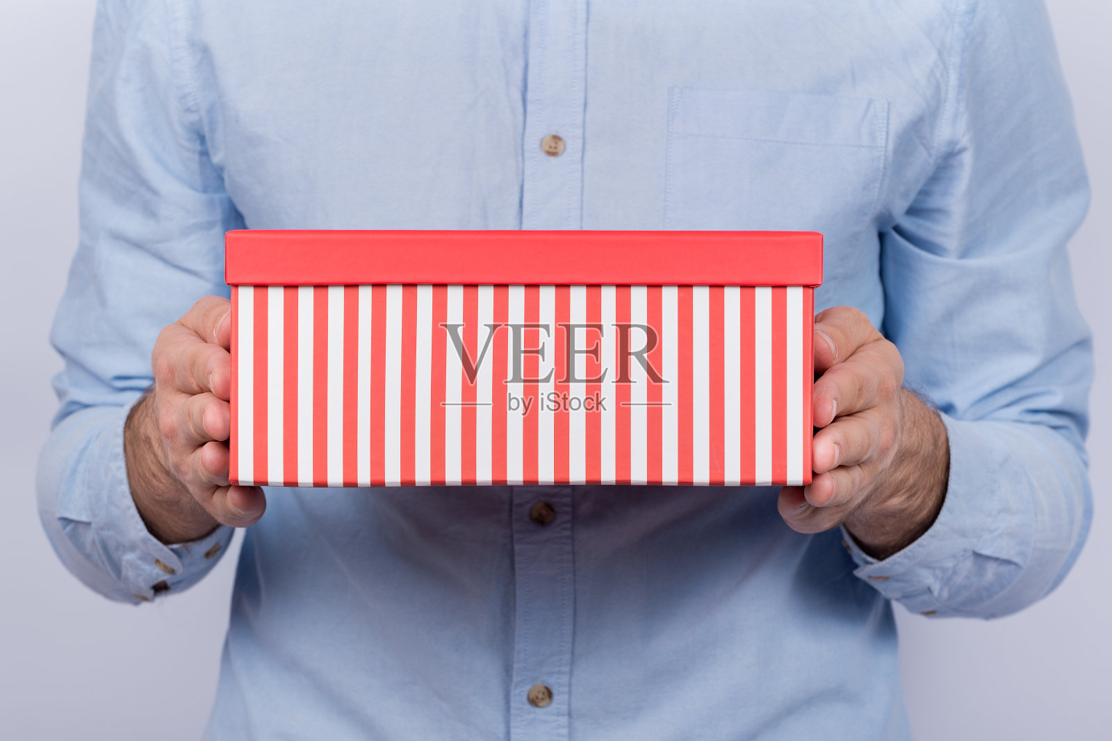男人拿着明亮的礼盒。航运礼物回家。前视图。照片摄影图片