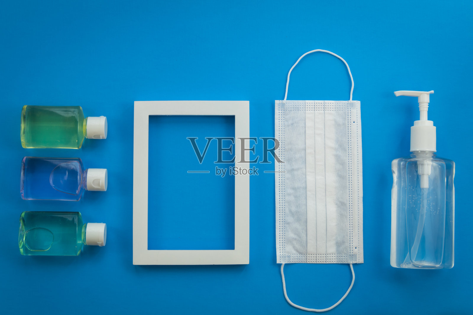 新的正常的保持安全健康的概念口罩和洗手液手套在蓝色平铺照片摄影图片
