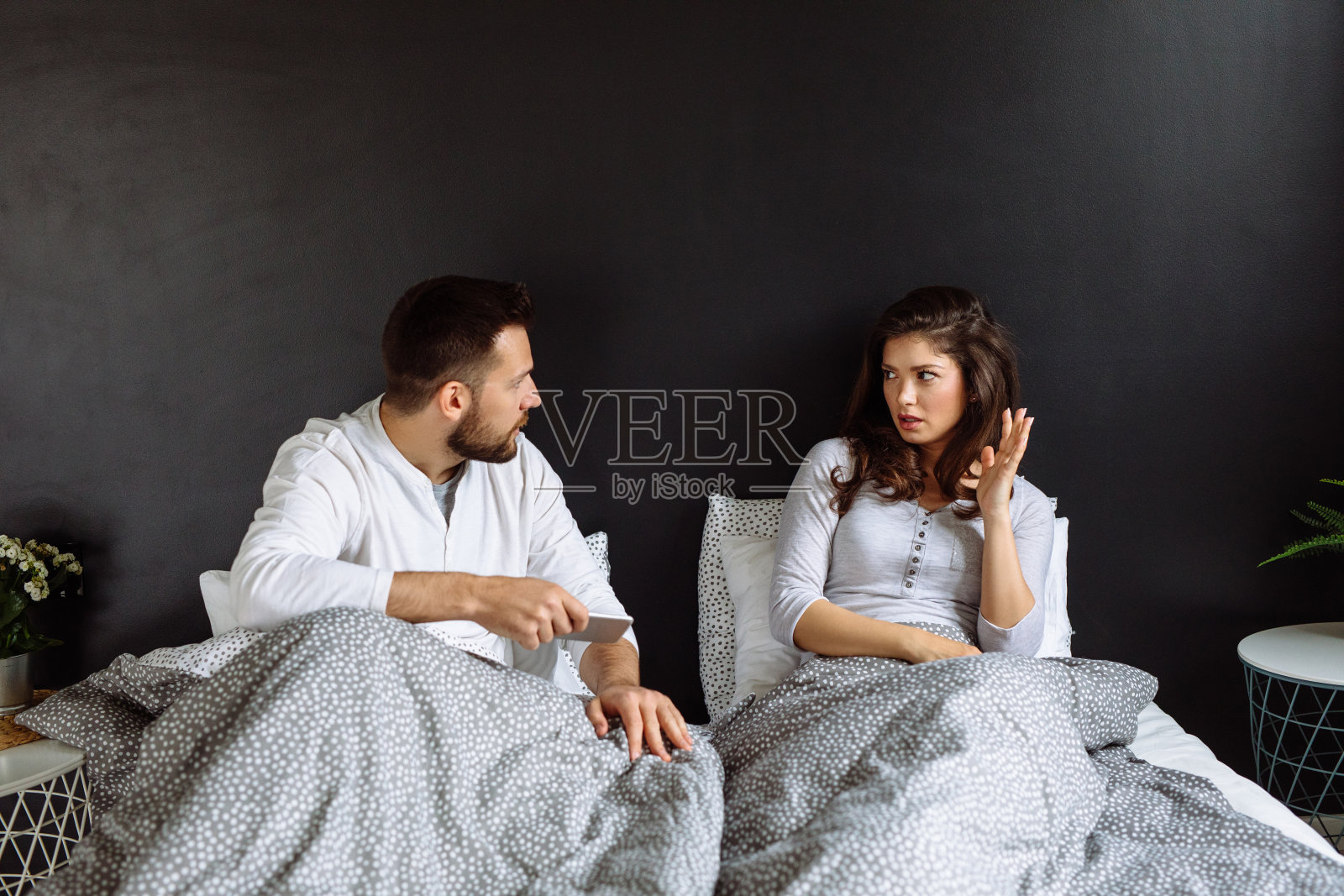 不满的年轻褐发女子与男友争吵智能手机图片-商业图片-正版原创图片下载购买-Veer图库