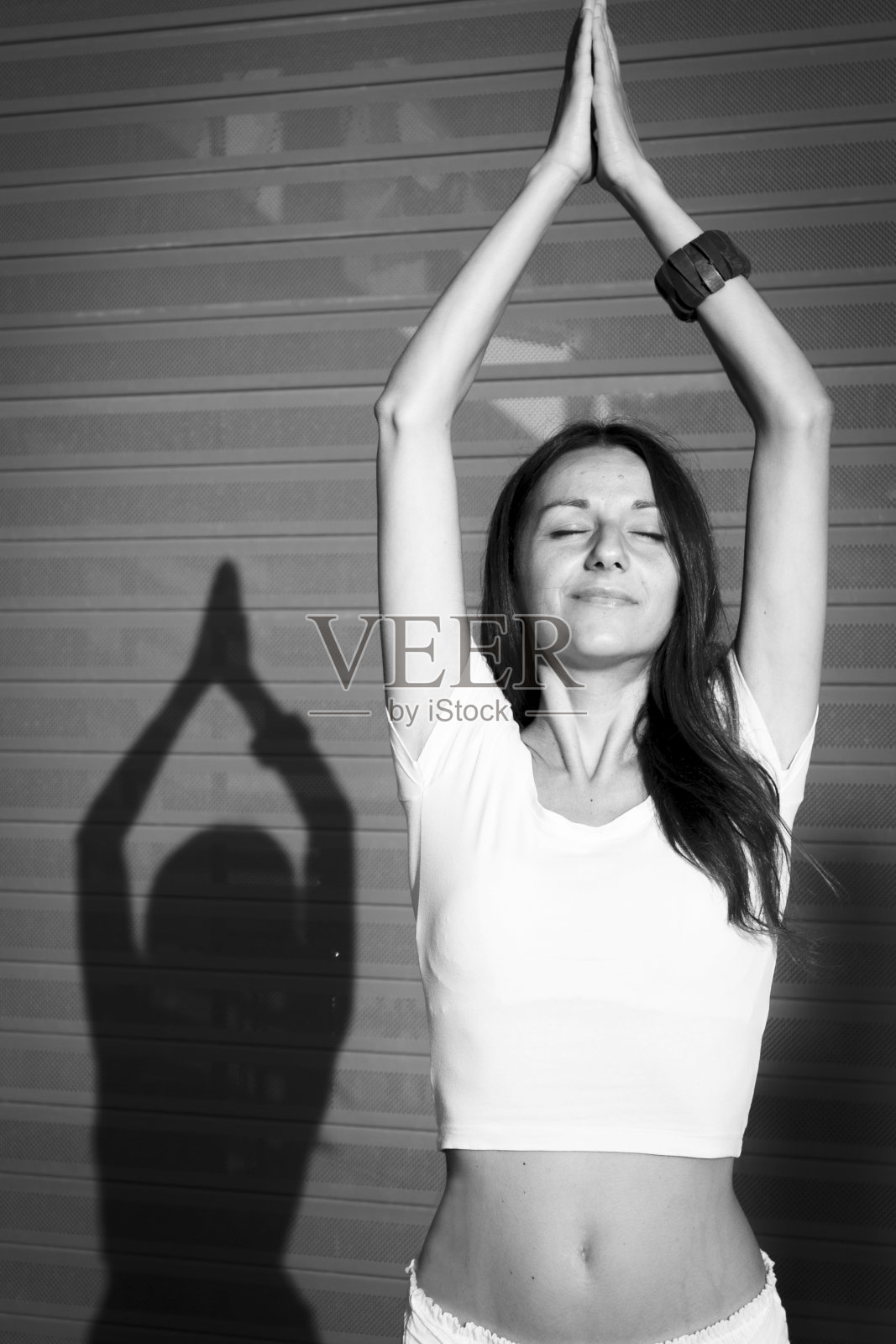 女孩穿着白色衣服，摆着瑜伽姿势，很有灵性。粉红色的使用照片摄影图片