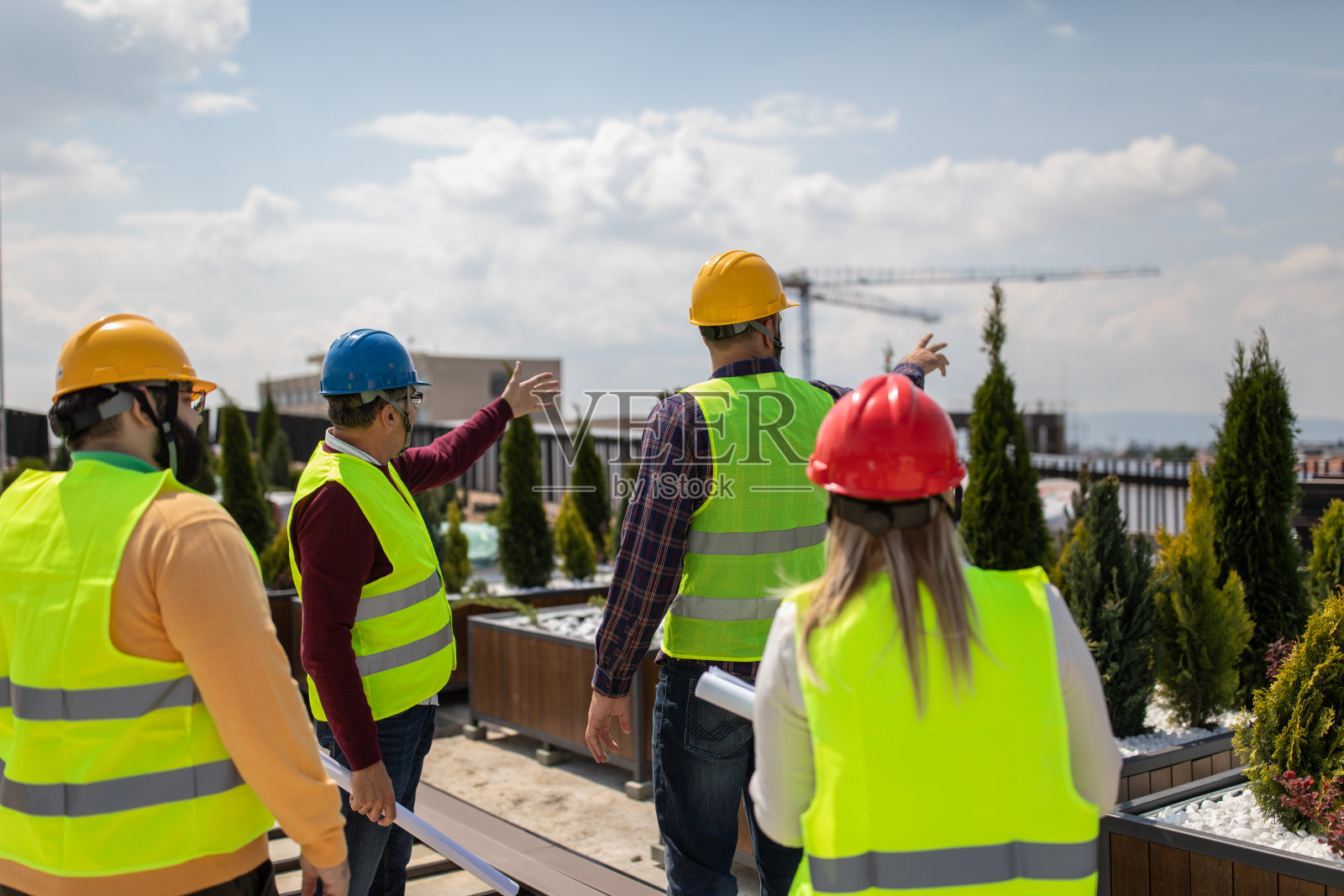 建筑工人和工程师站在建筑的屋顶上谈论工作照片摄影图片