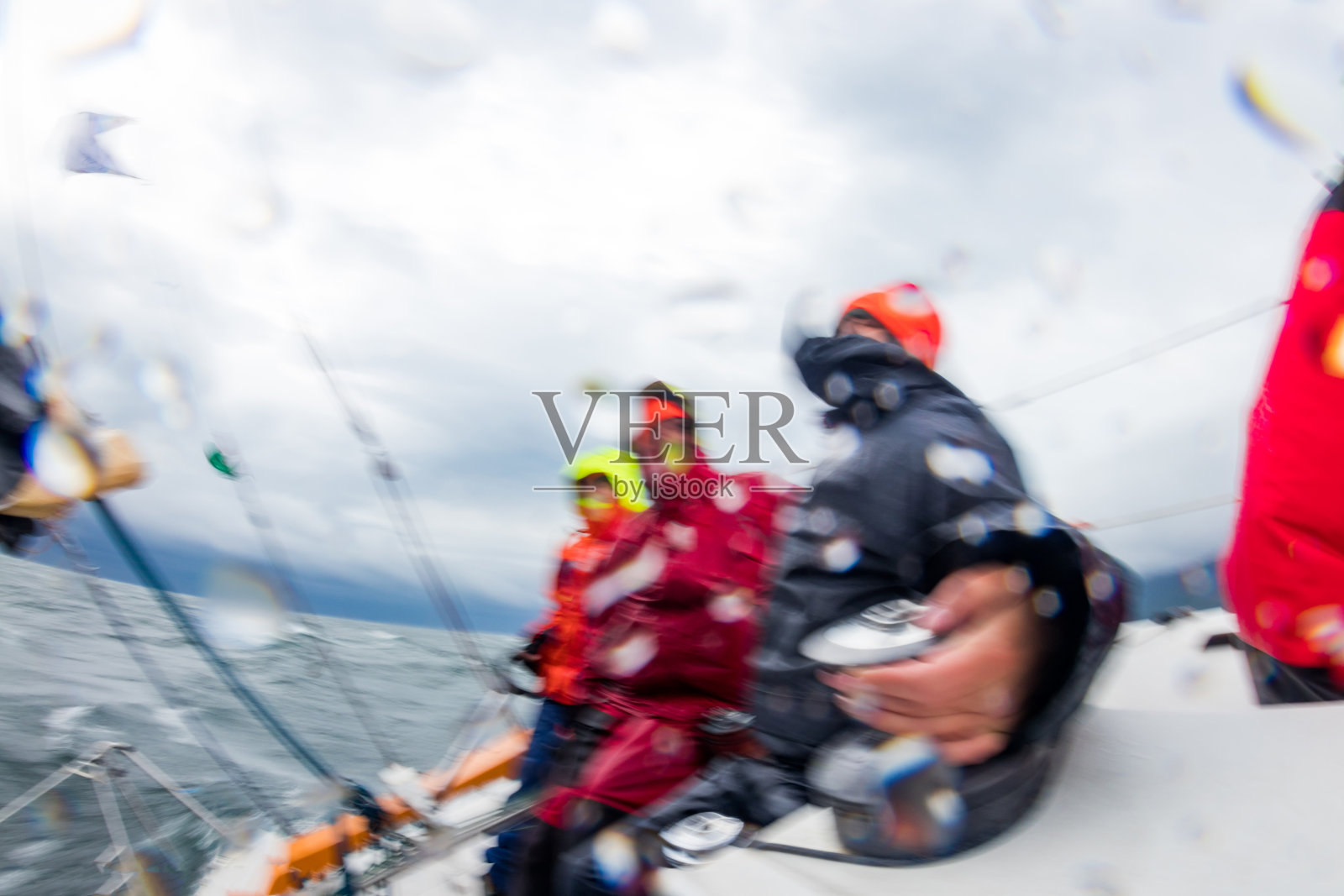 运动模糊与溅人与航行的游艇在困难的风暴海。现在男人的运动是游艇照片摄影图片