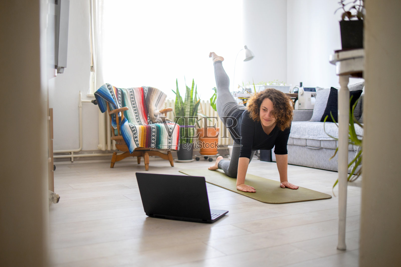 年轻女子在家里练习瑜伽照片摄影图片