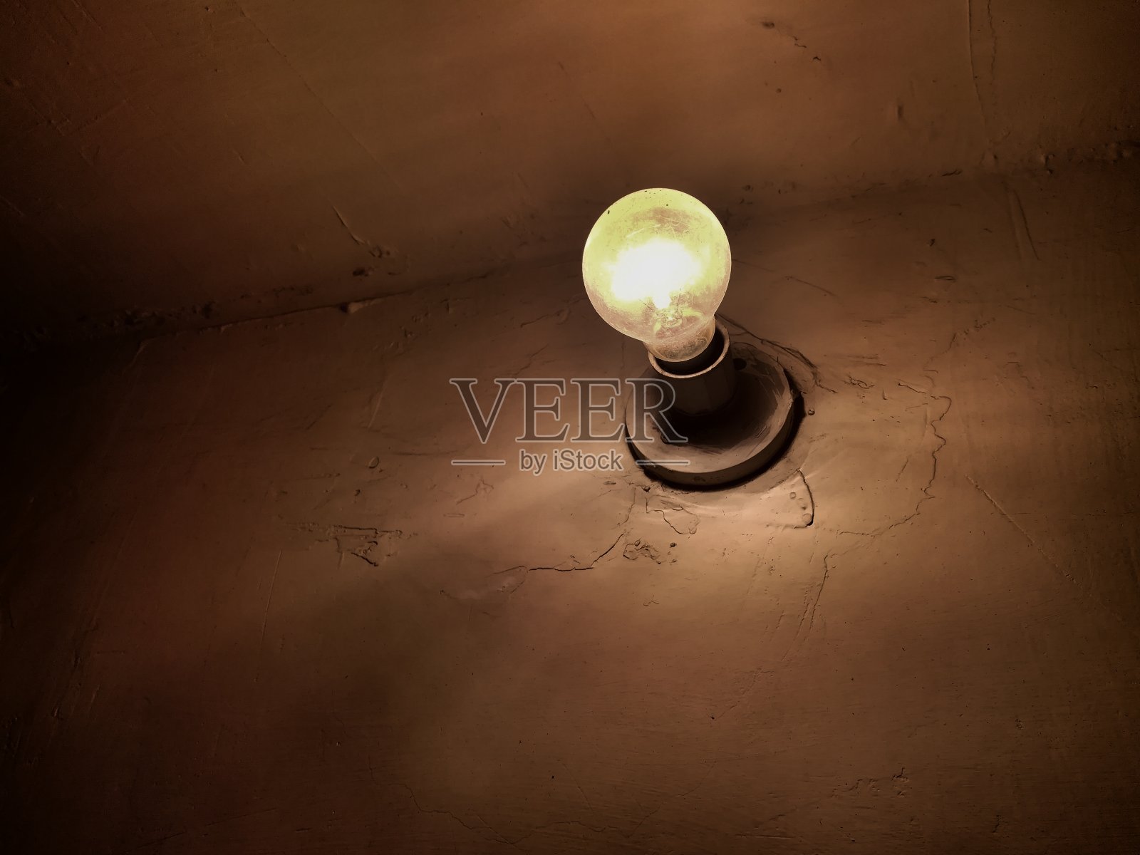 黄色电灯泡在孤立的墙上照片摄影图片