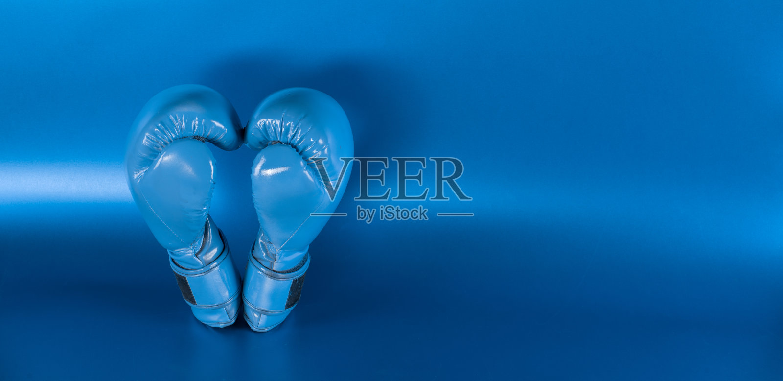 蓝色背景上的蓝色拳击手套照片摄影图片