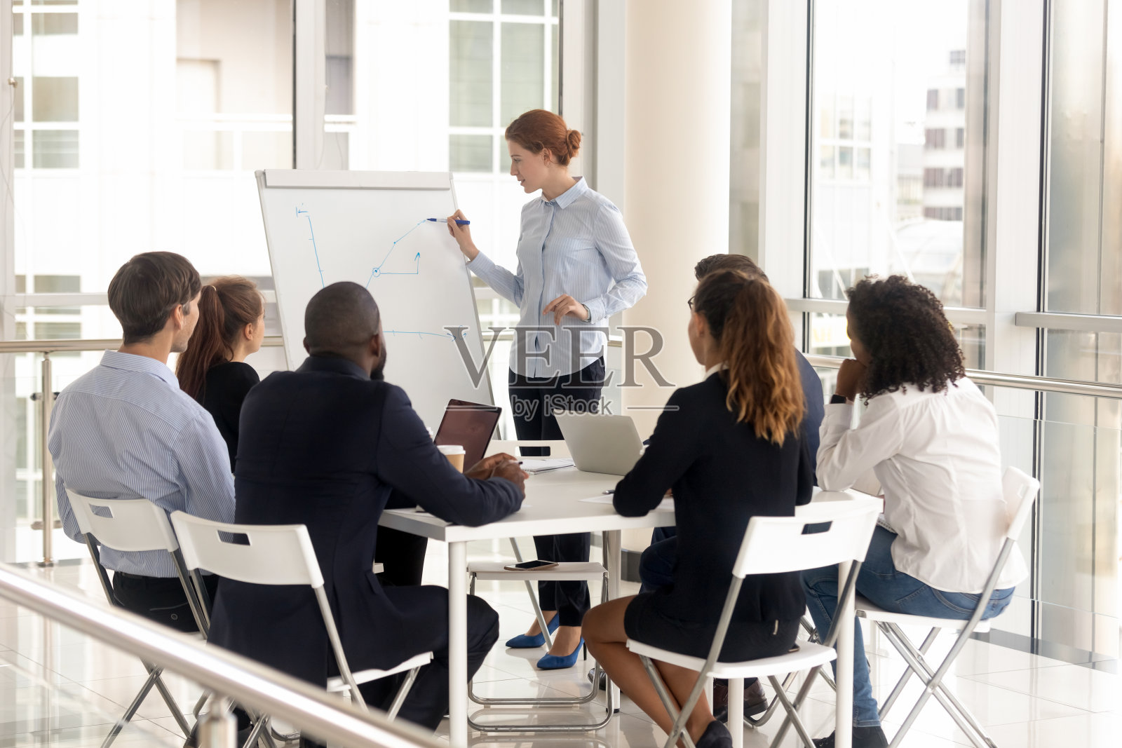 年轻女员工，演示时带挂图。照片摄影图片