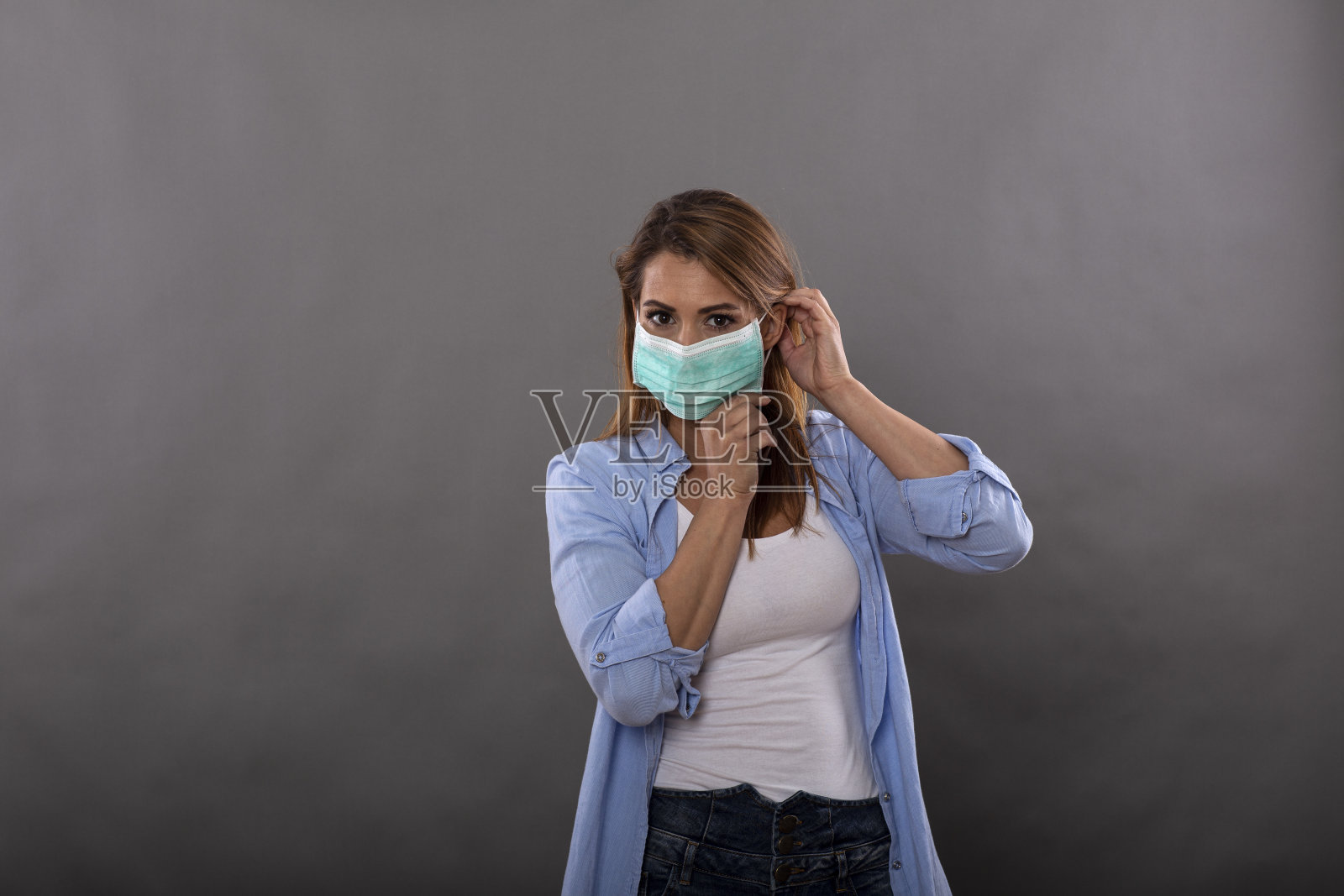 女人戴着防护面具，防止病毒在演播室拍摄照片摄影图片