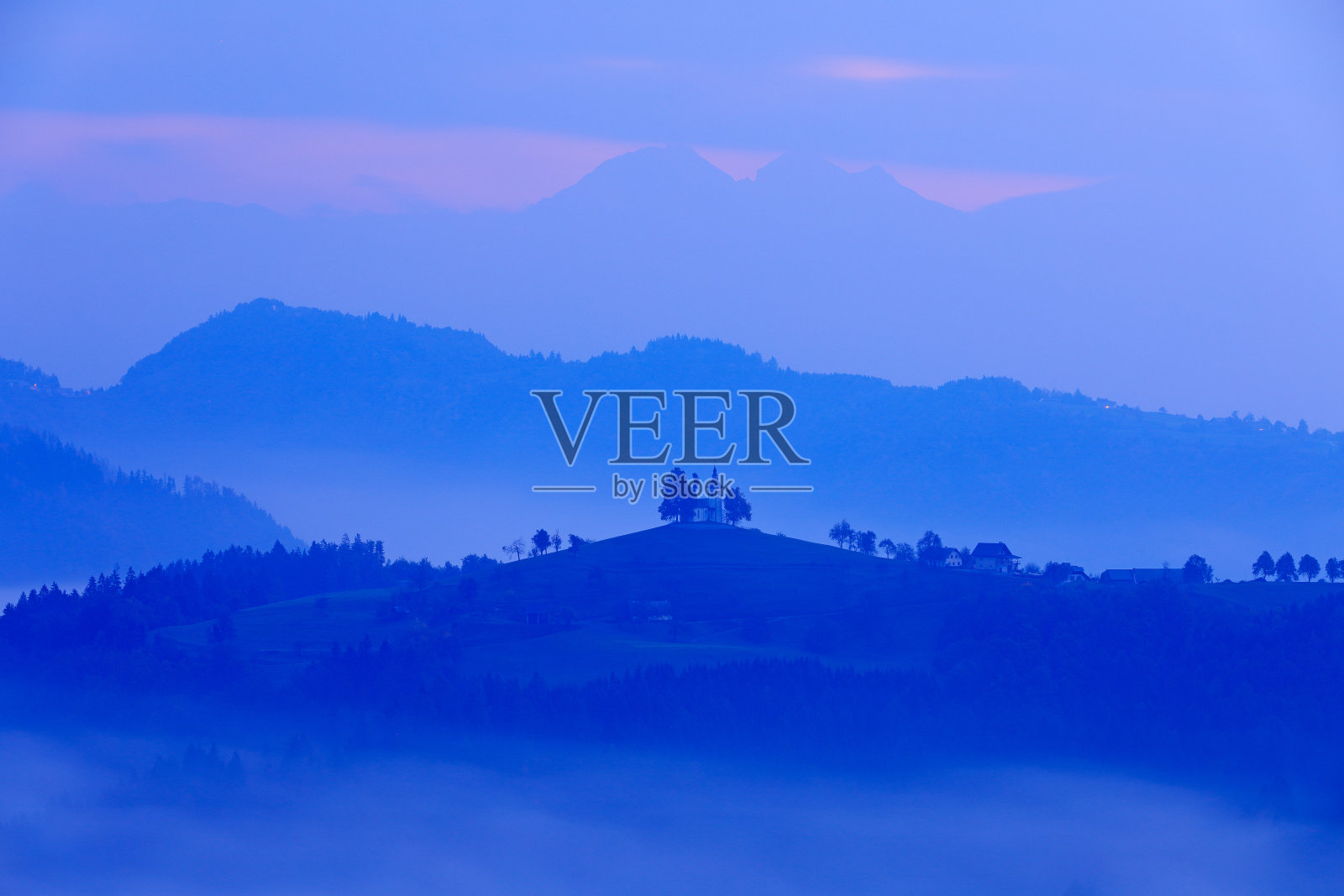 圣托马斯教堂，Sveti Tomaz nad Praprotnim, Skofja Loka。斯洛文尼亚的风景，欧洲的自然。多雾的特里格拉夫阿尔卑斯森林，斯洛文尼亚旅游。美丽日出伴天空，绿色自然。照片摄影图片