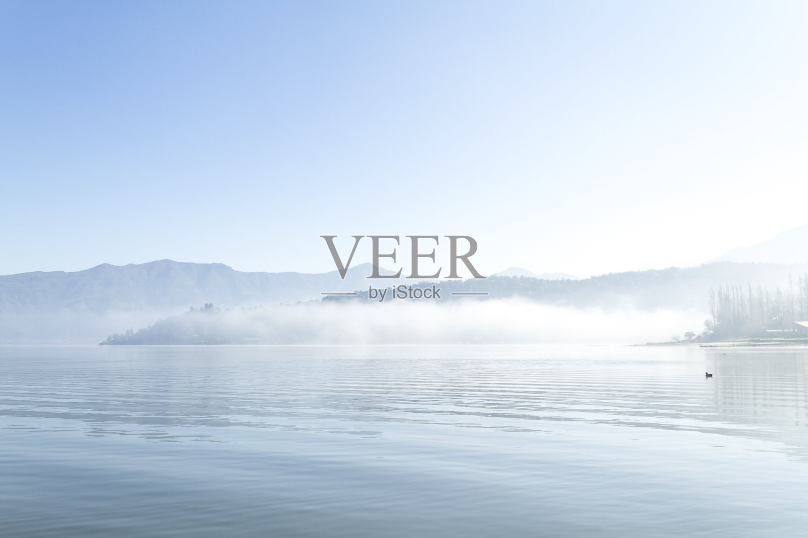 美丽的巴塔哥尼亚风景安第斯山脉与高山与发光的山峰，石头在山湖，反射，蓝天和雾在日出。照片摄影图片