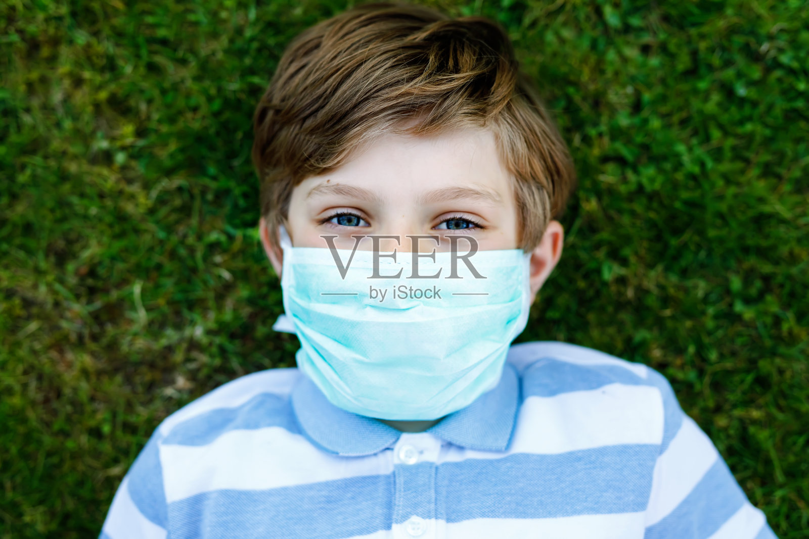 可爱的小男孩戴着医用口罩，抵御冠状病毒隔离疾病。在校儿童使用防护设备抗击covid - 19。照片摄影图片