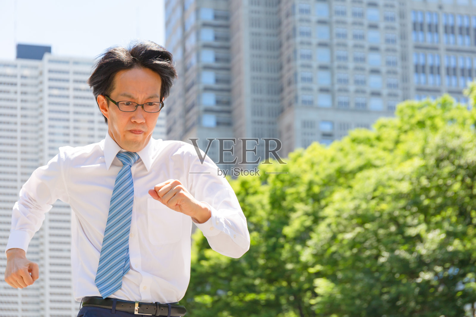 一个瘦骨嶙峋、神情严肃的日本商人正在跑步照片摄影图片