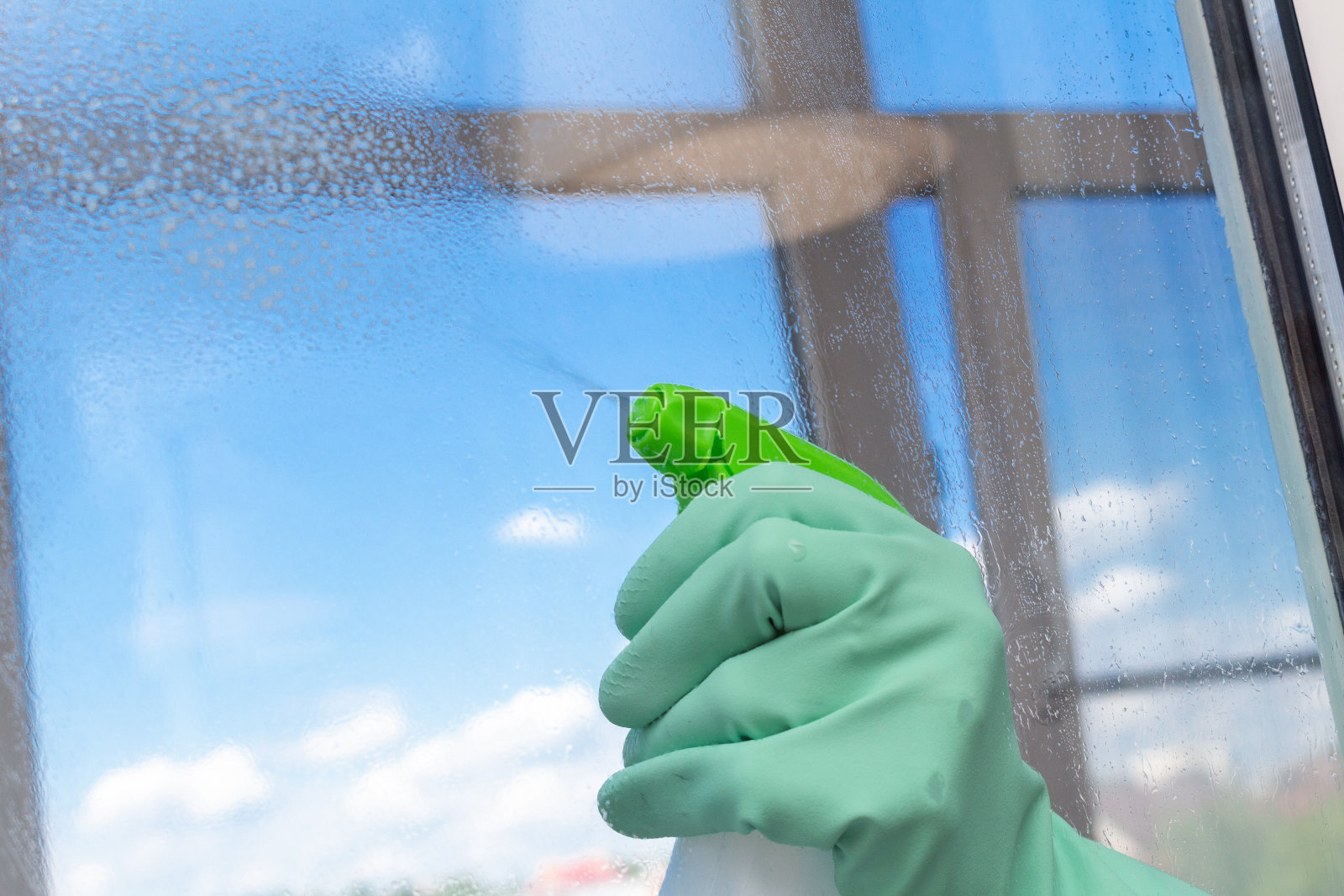 在蓝色的天空背景上用特殊的笔刷清洗窗口。清洁服务。照片摄影图片