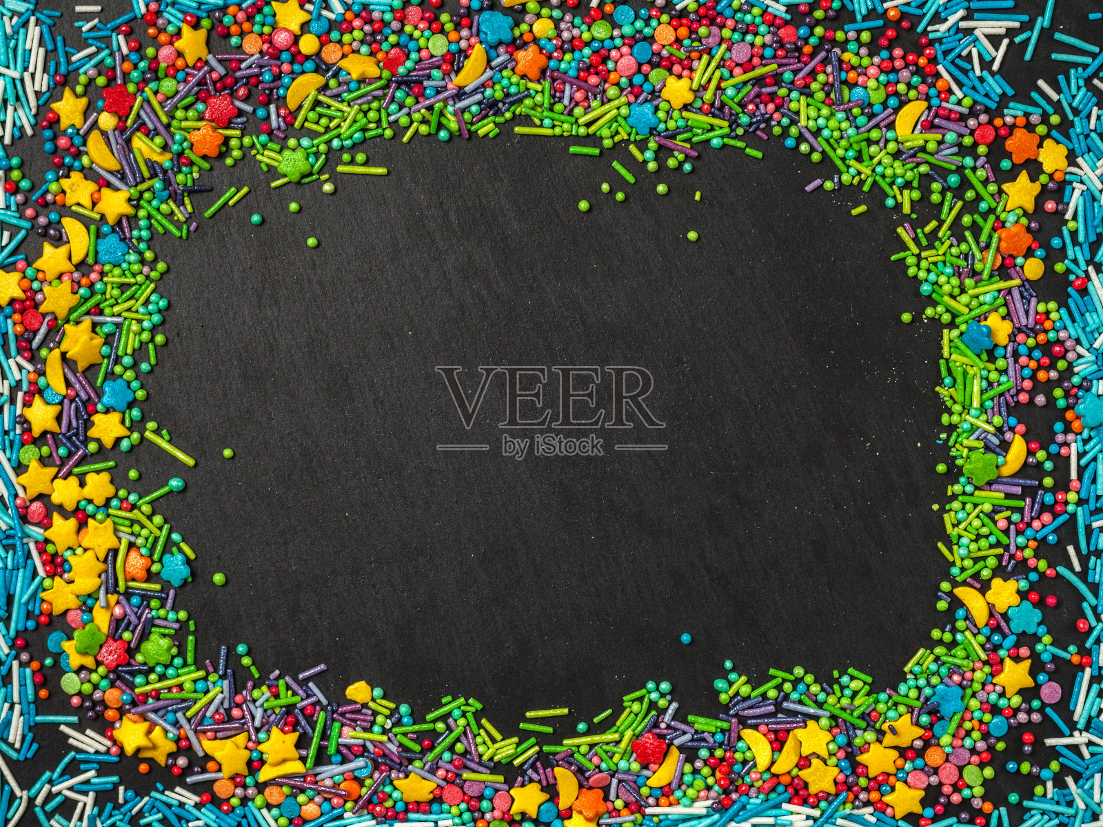 洒的。糖果的概念。黑色背景上的甜蜜五彩纸屑。小蛋糕，甜甜圈，甜点，面包房背景。照片摄影图片