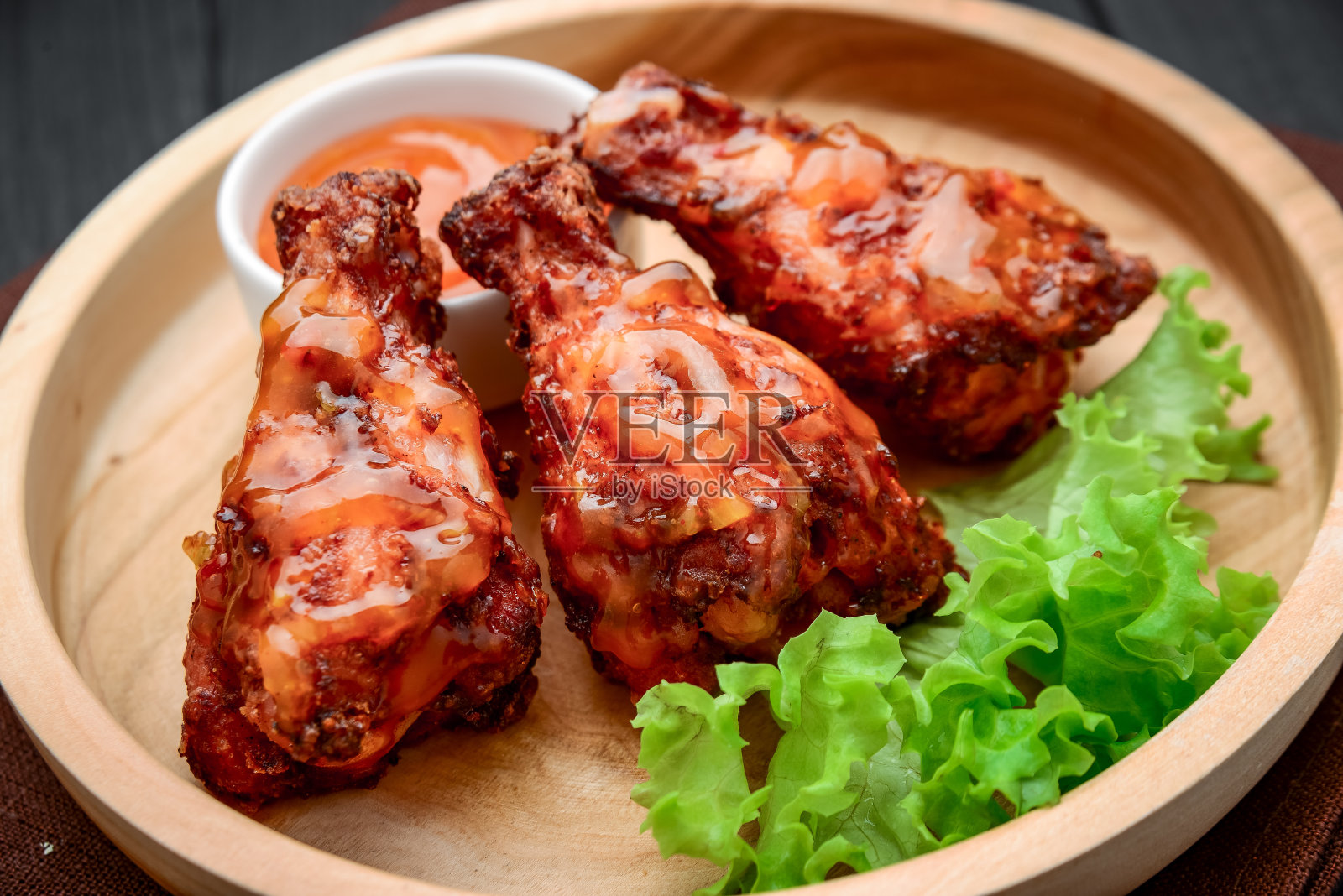 烤鸡翅配辣酱放在木盘上照片摄影图片